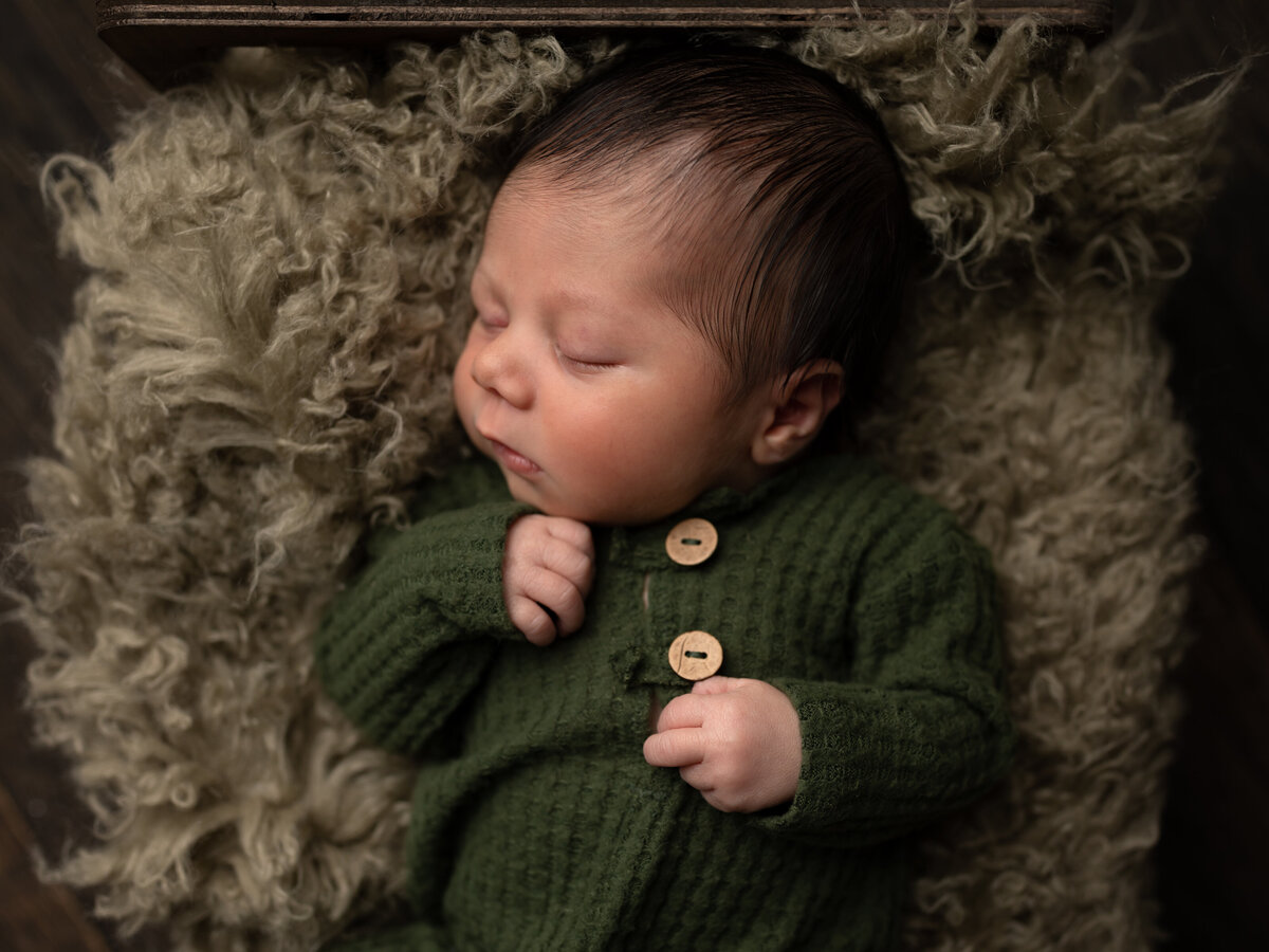 newborn baby boy in green outfit for studio portraits
