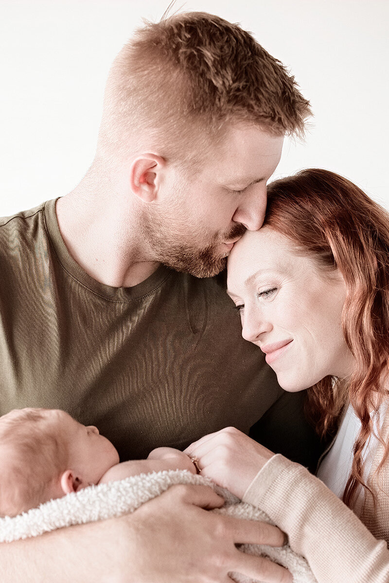 Dad loving mom with baby
