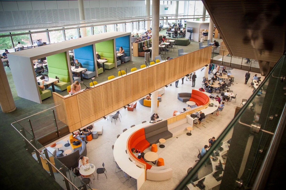 Bright and open interior of Western Sydney University’s Penrith campus library featuring curved desks, collaborative seating areas, and overhead natural light.