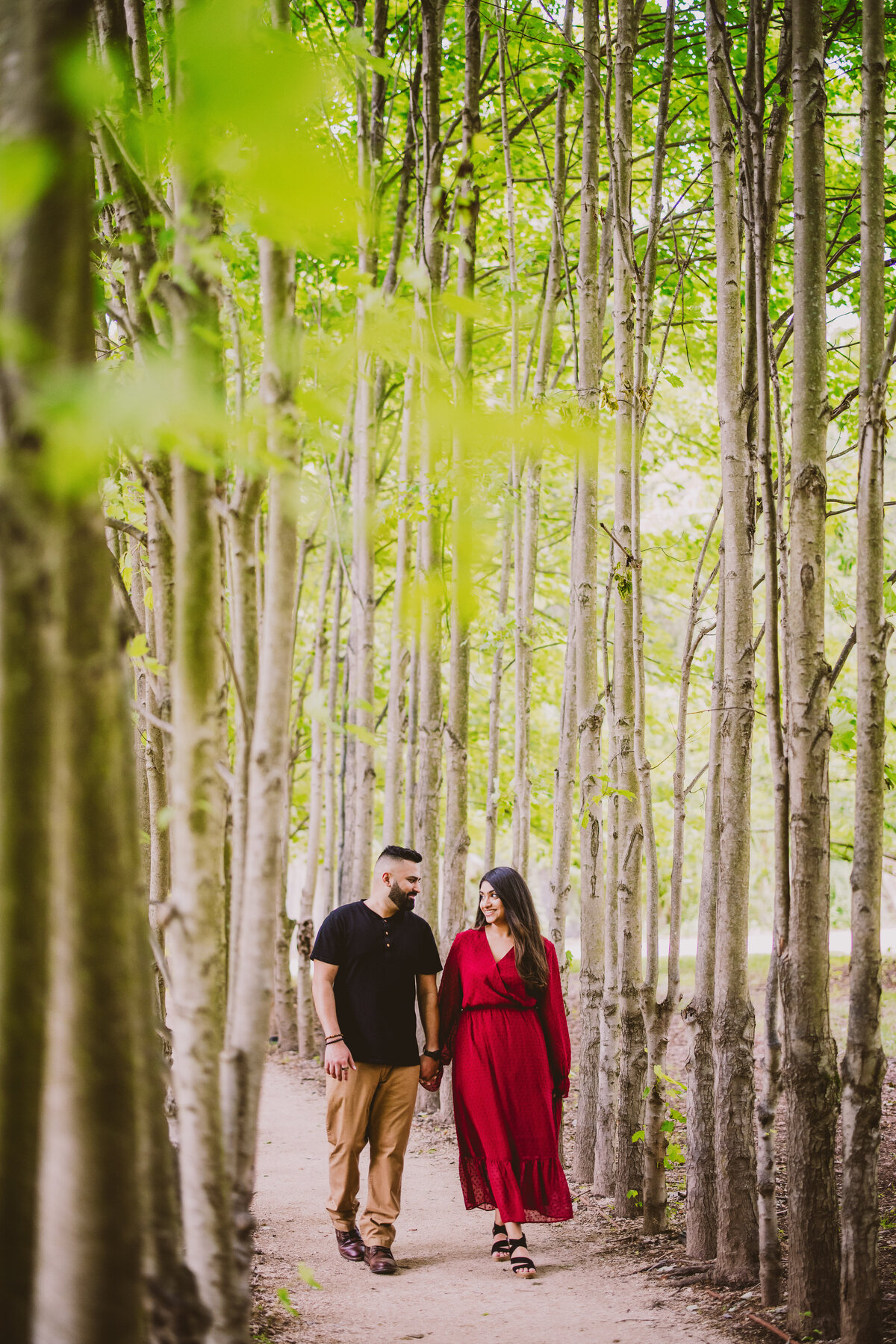 A couple walking down the tree allee at the grounds for sculpture in new jersey during their engagement session