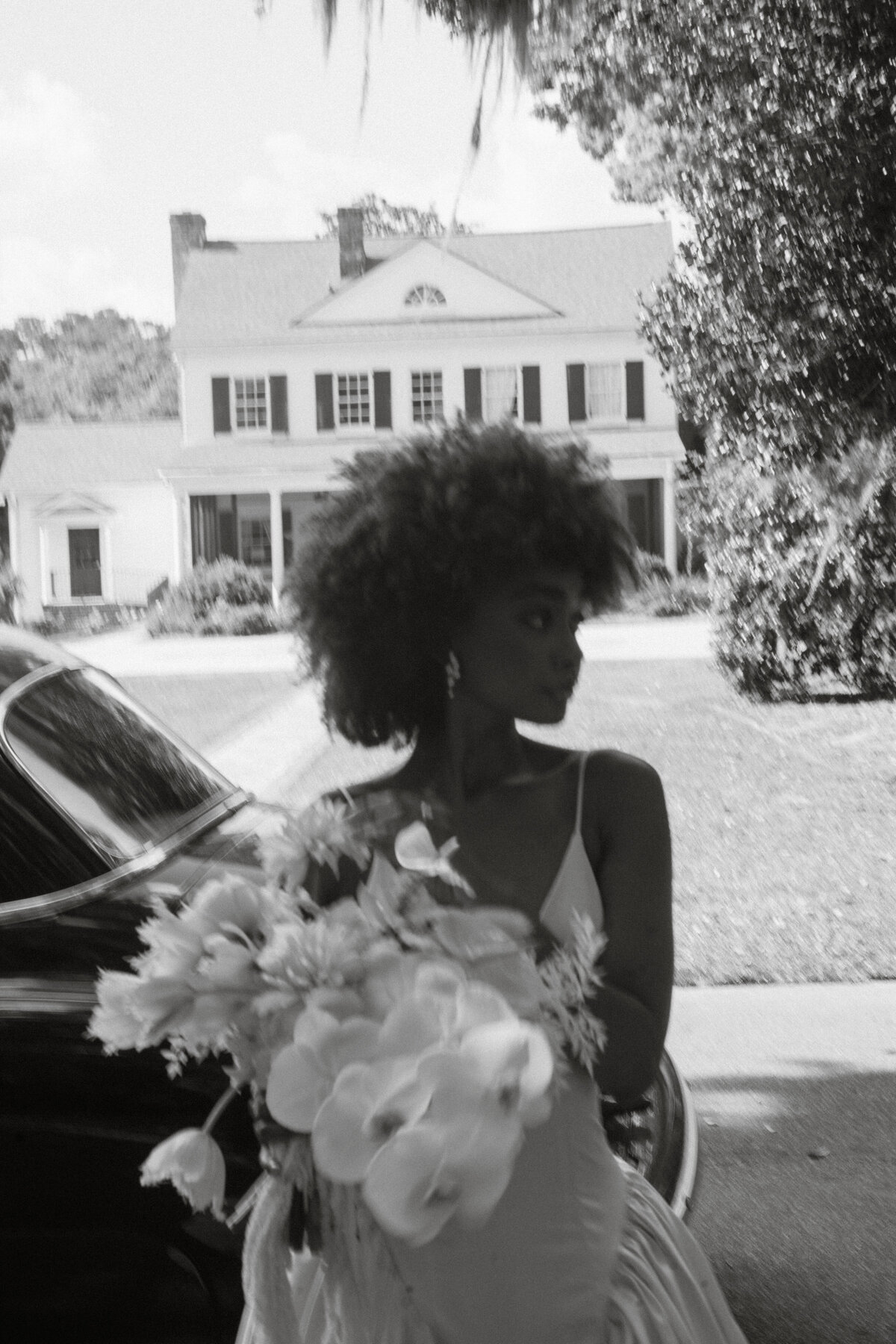 bride holding a bouquet of flowers in front of Legare Waring House