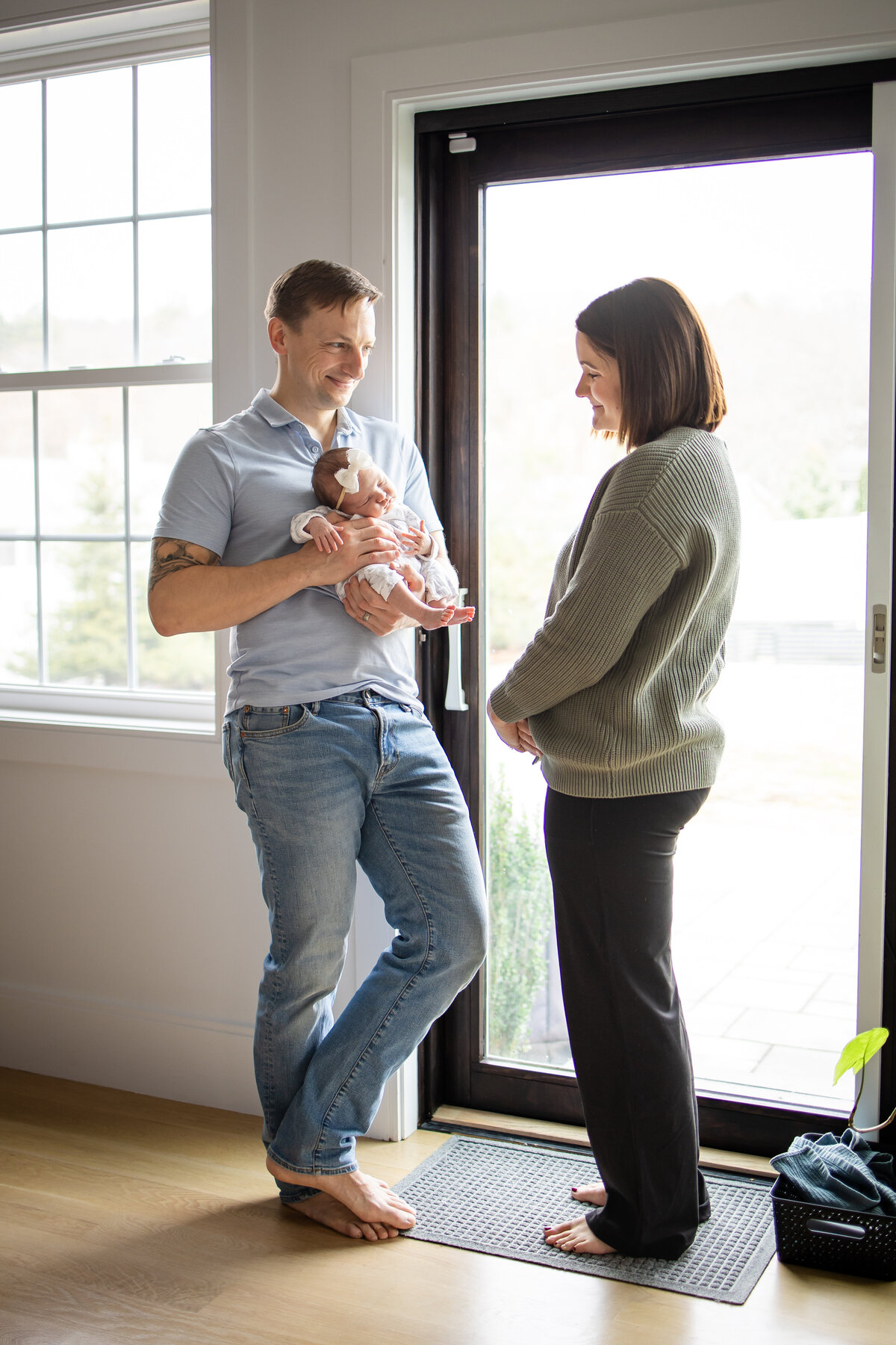 Dad looking at Mom while she looks at the baby in dad's arms