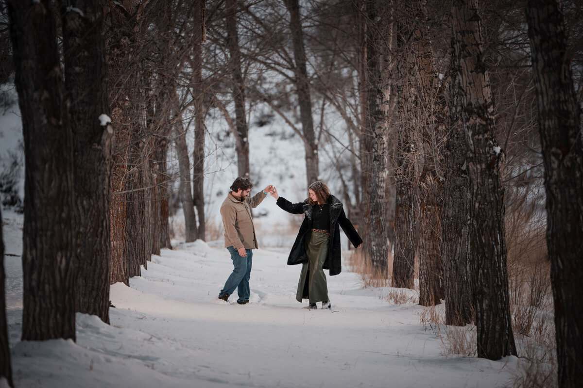 Couple standing beneath brilliant orange aspen leaves in Snowmass