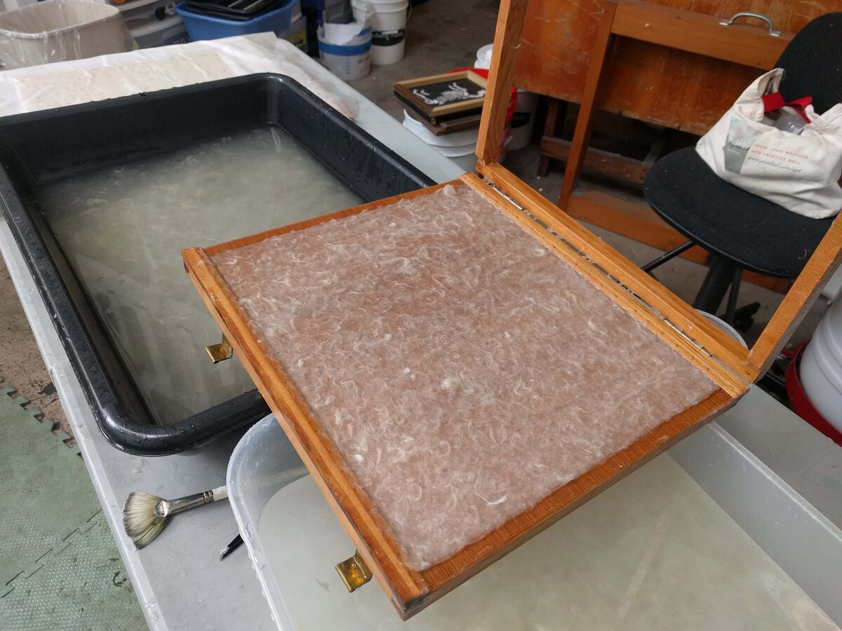 Sugeta resting on a vat of water pulp, showing the setup used in Japanese-style papermaking.
