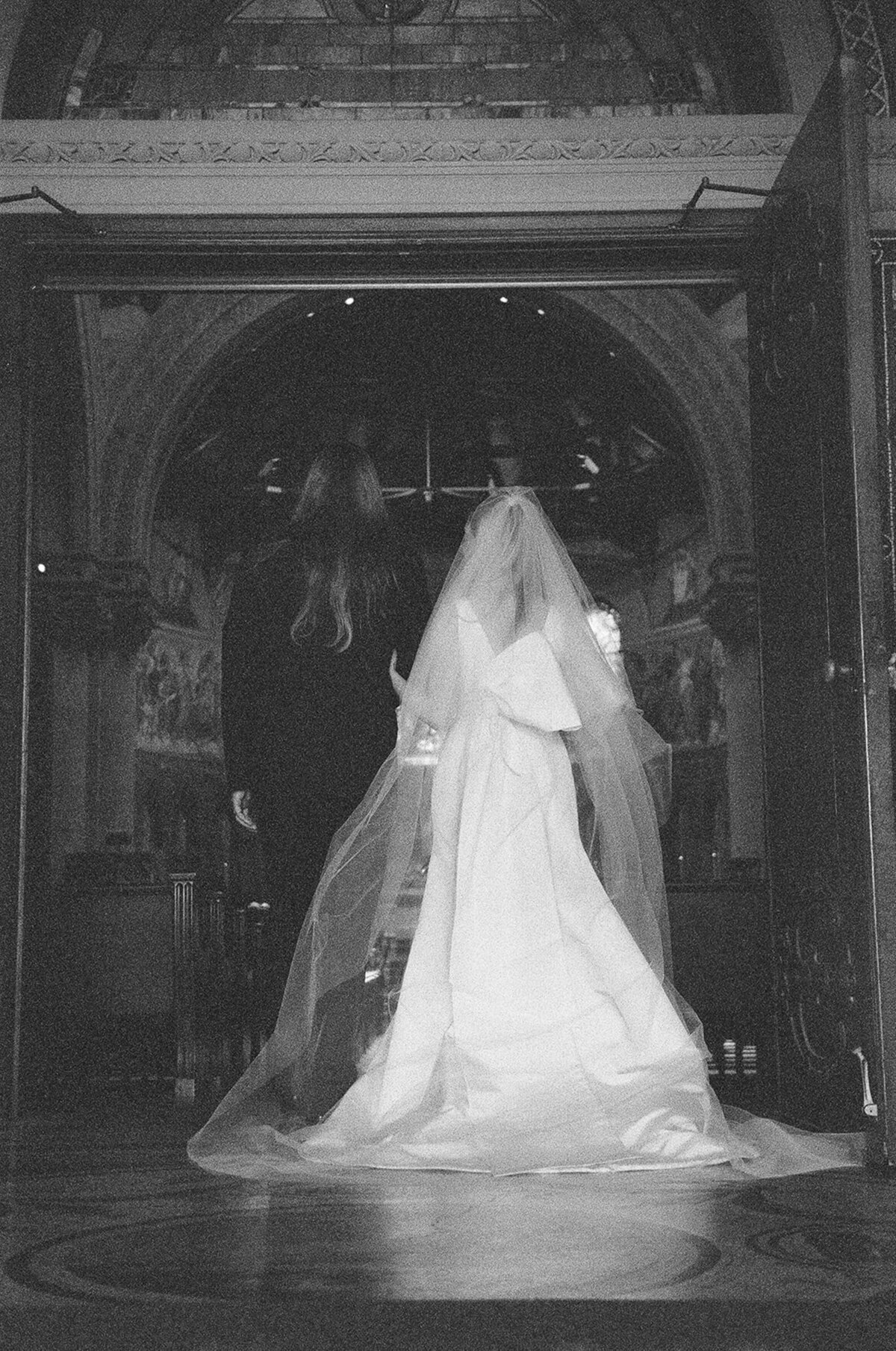 bride and groom in a grainy black and white photo entering church