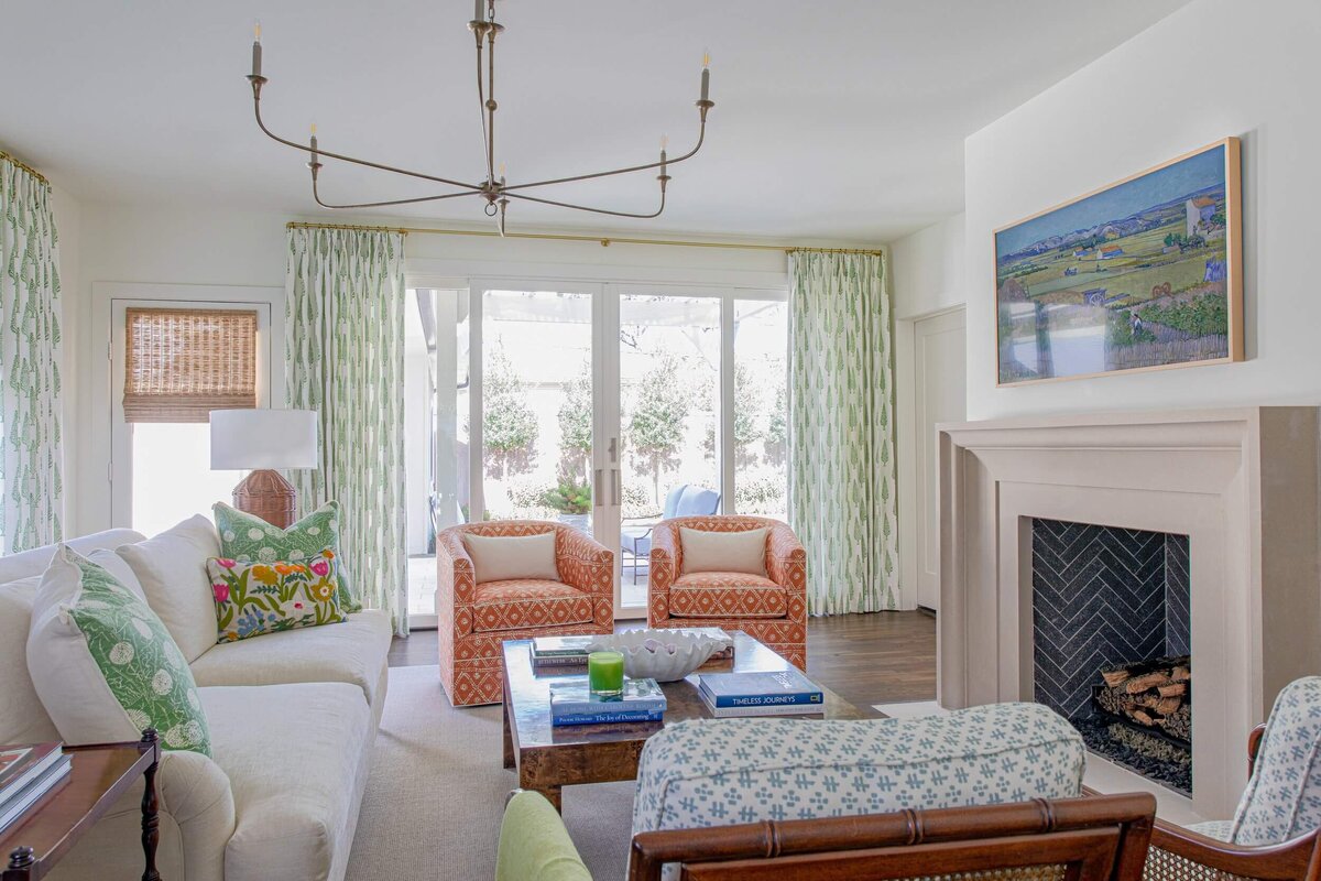 oyster creek studios highland park home white couch and red chairs around a fireplace in a living room