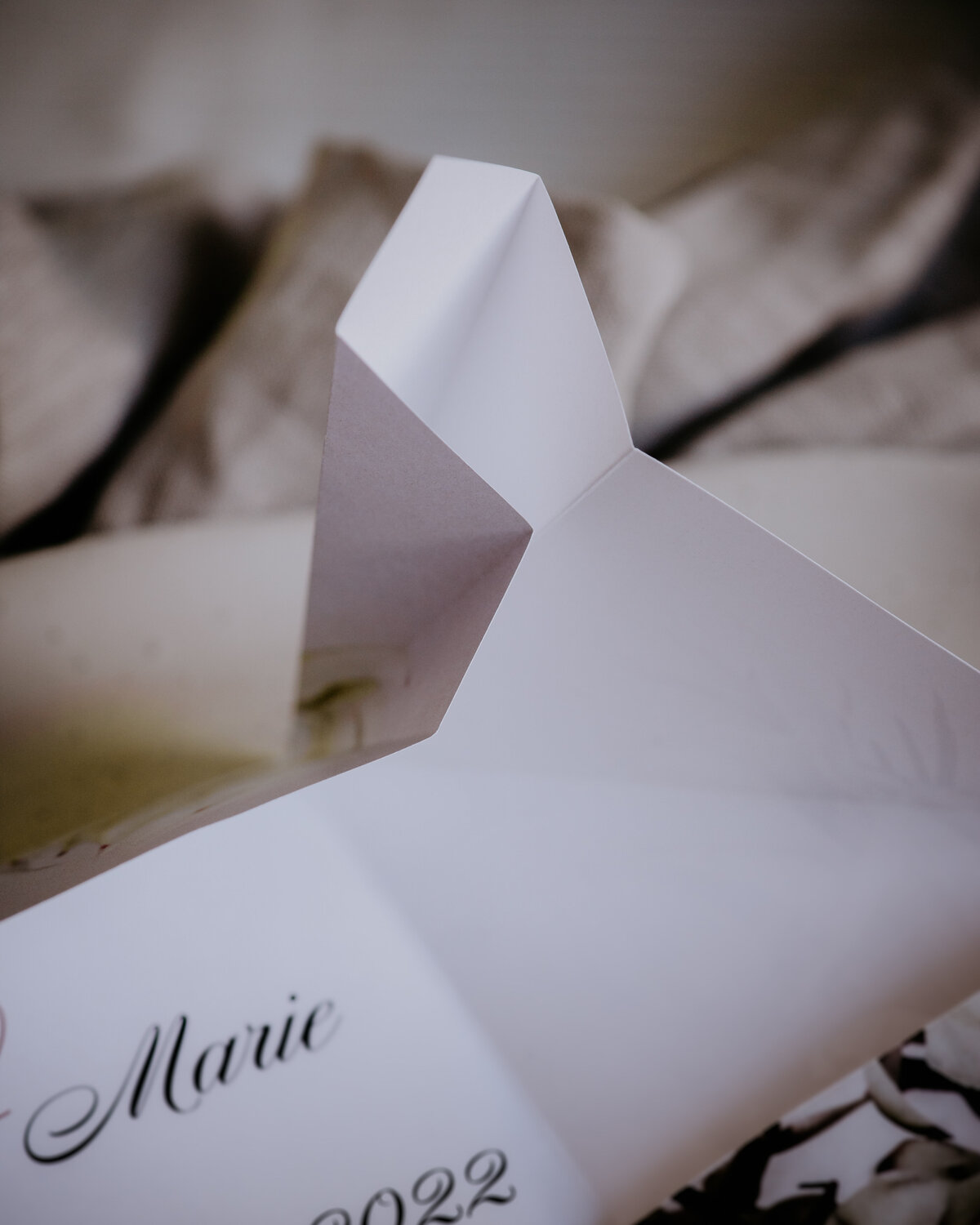Folded detailing on a white origami wedding invitation
