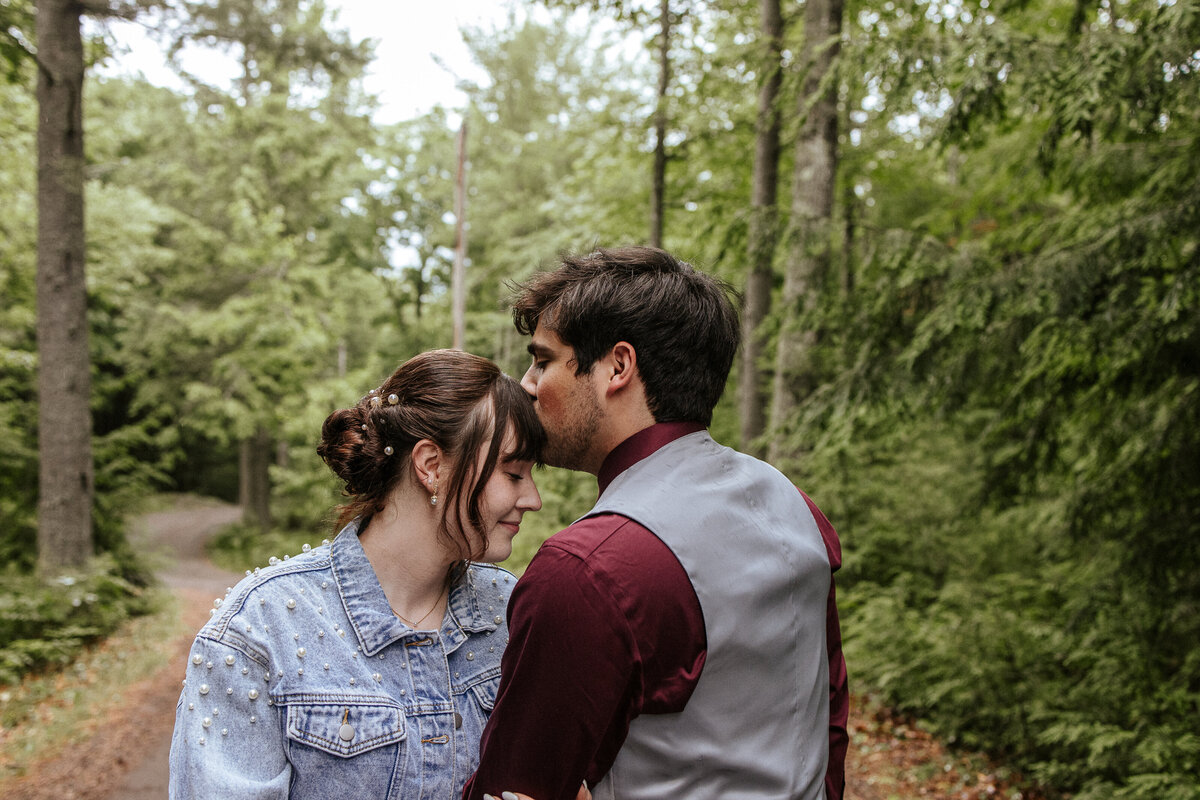 Backyard wedding: couple taking a portrait along their long driveway surrounded by greenery and nature.