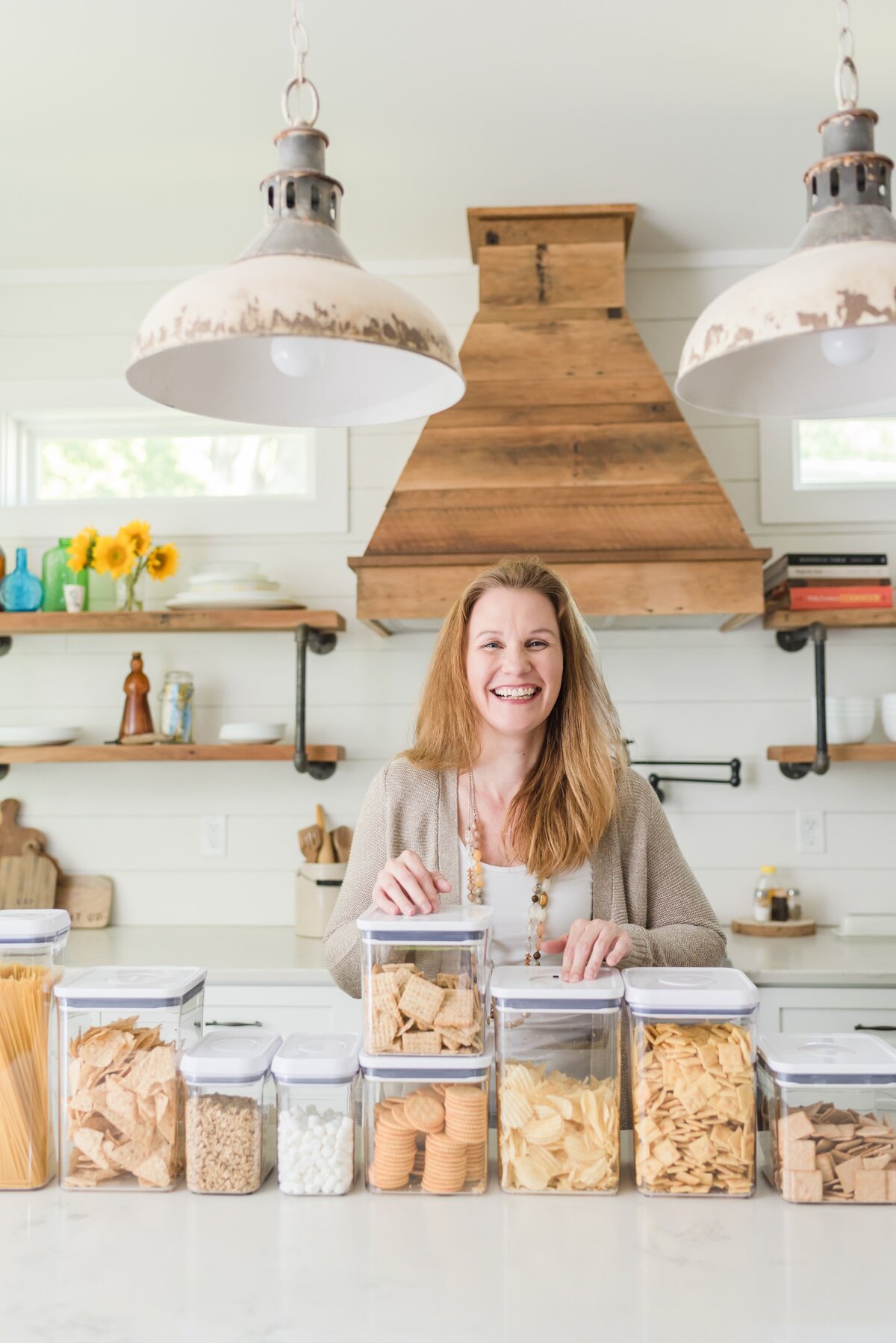 Lifestyle headshot of a Nashville home organizer in her kitchen with food containers in front of her