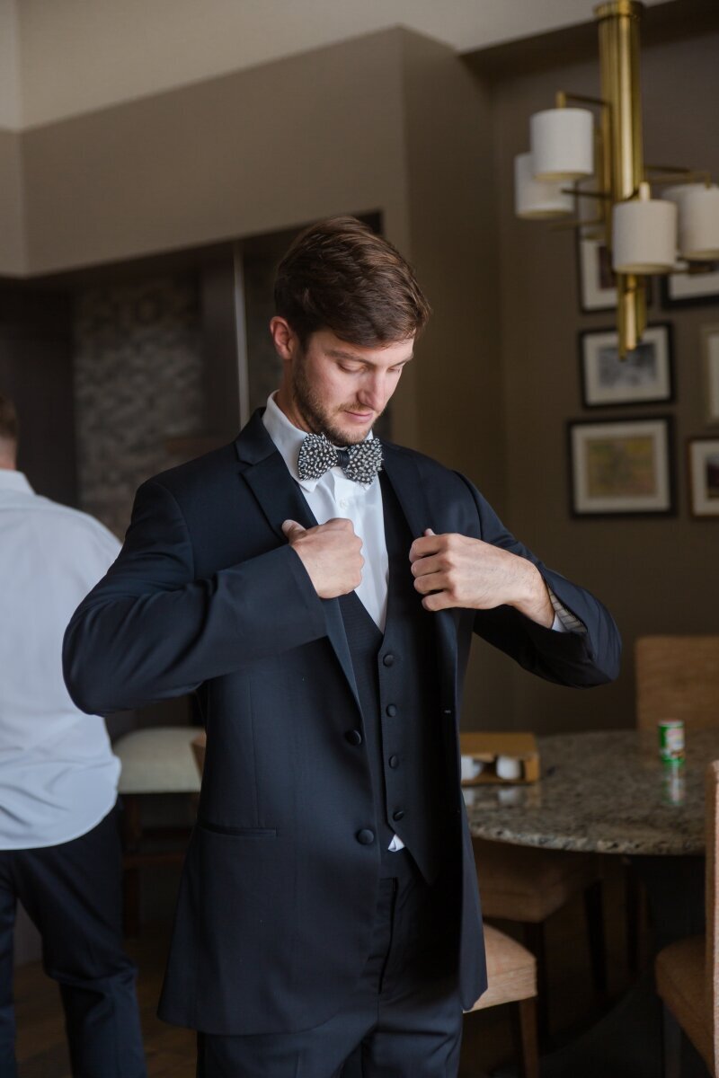 Adjusting tux Groom getting ready