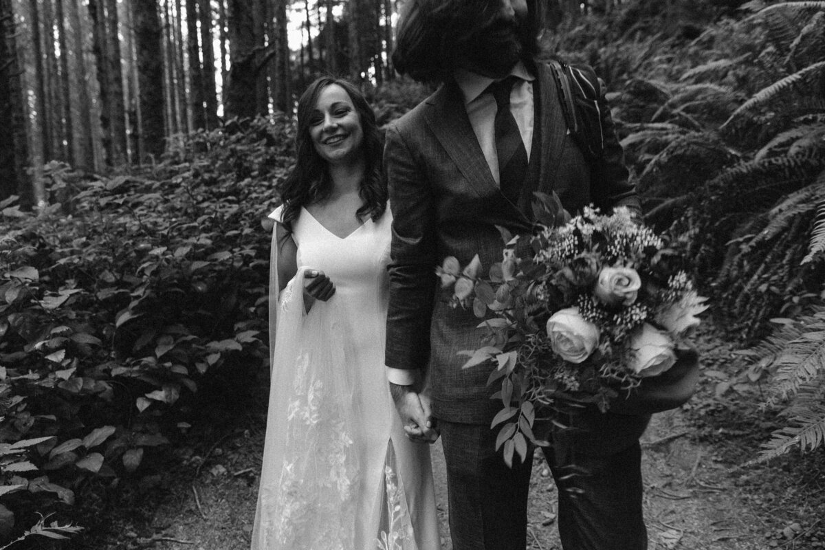 black and white image bride and groom in forest