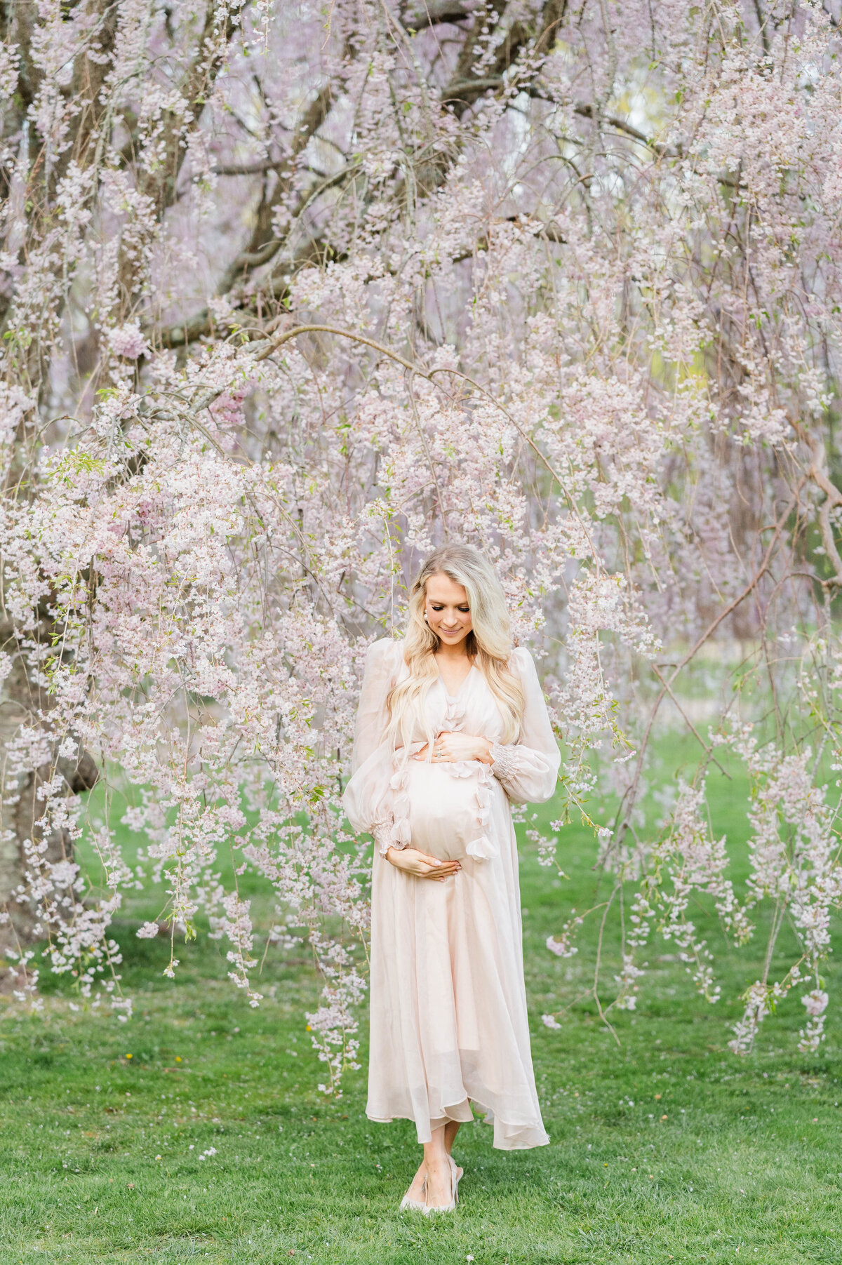 Pregnant woman holding belly in Bristol, RI at Blithewold Mansion taken by best Maternity photographer in Rhode Island