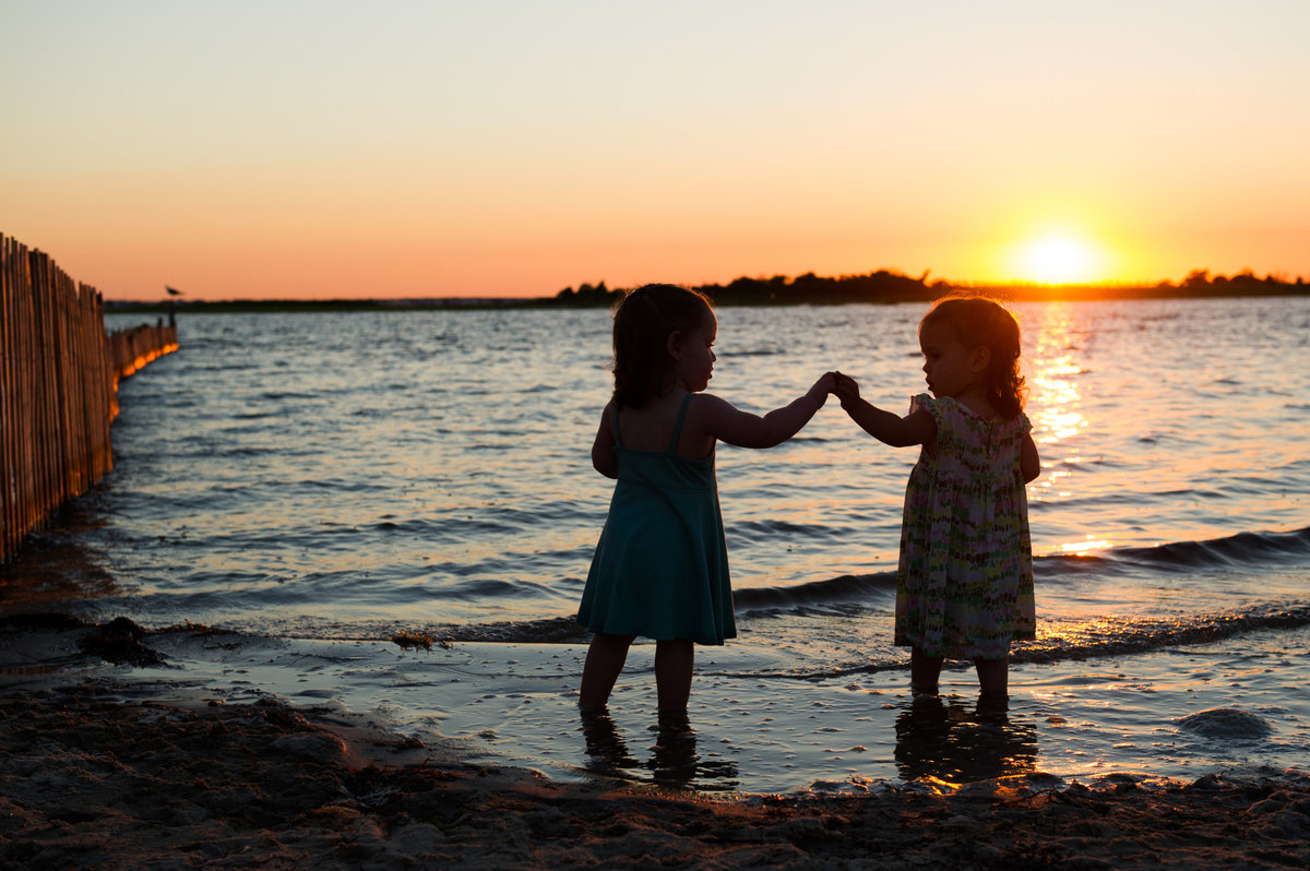 twin girls play at sunset