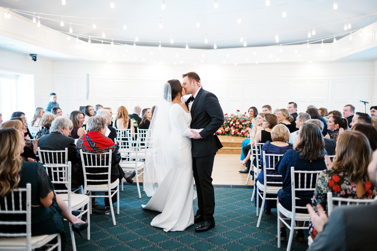 Bride and groom kissing at St. Paul College Club wedding ceremony