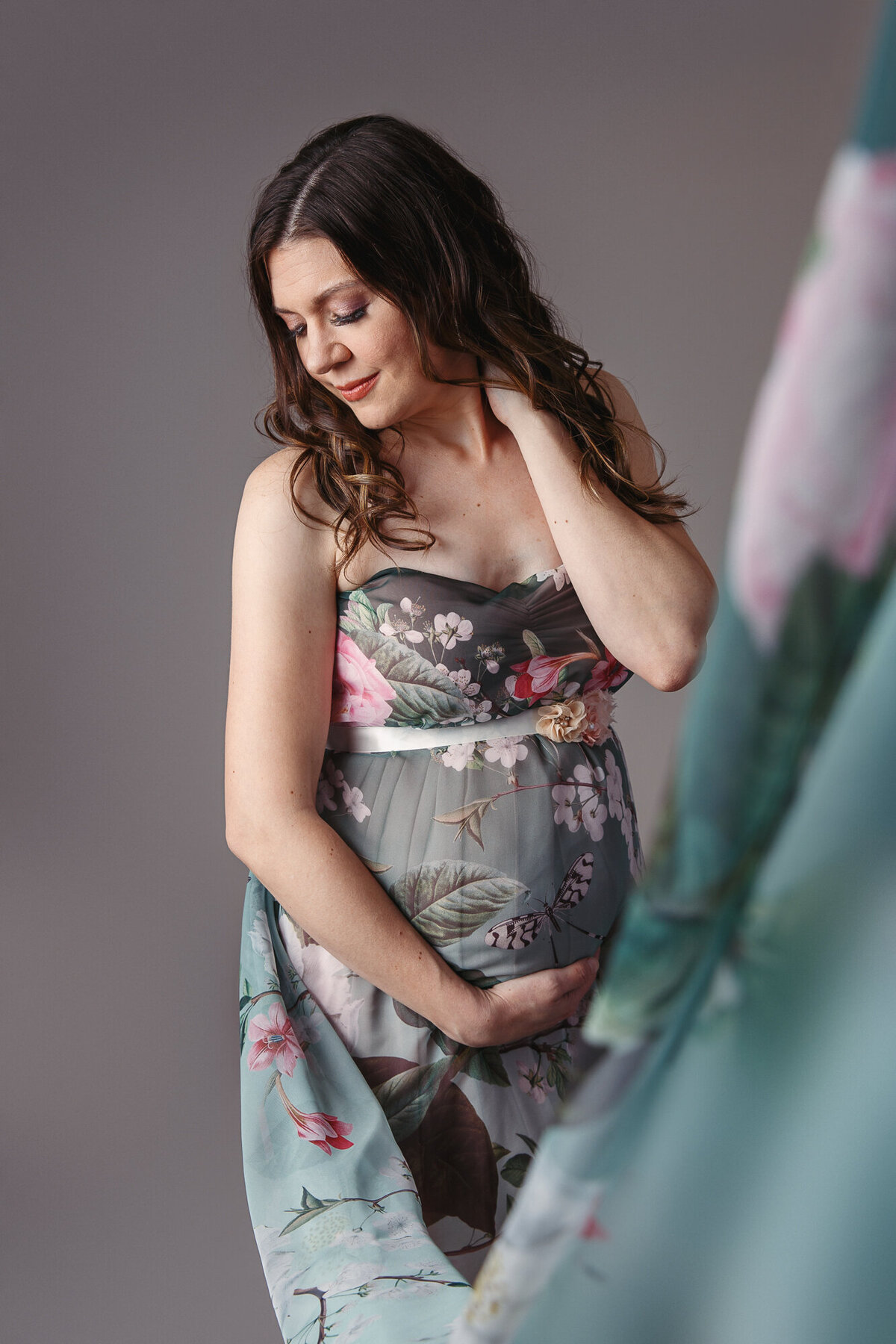 Portrait of a pregnant woman looking beautiful in a green floral dress