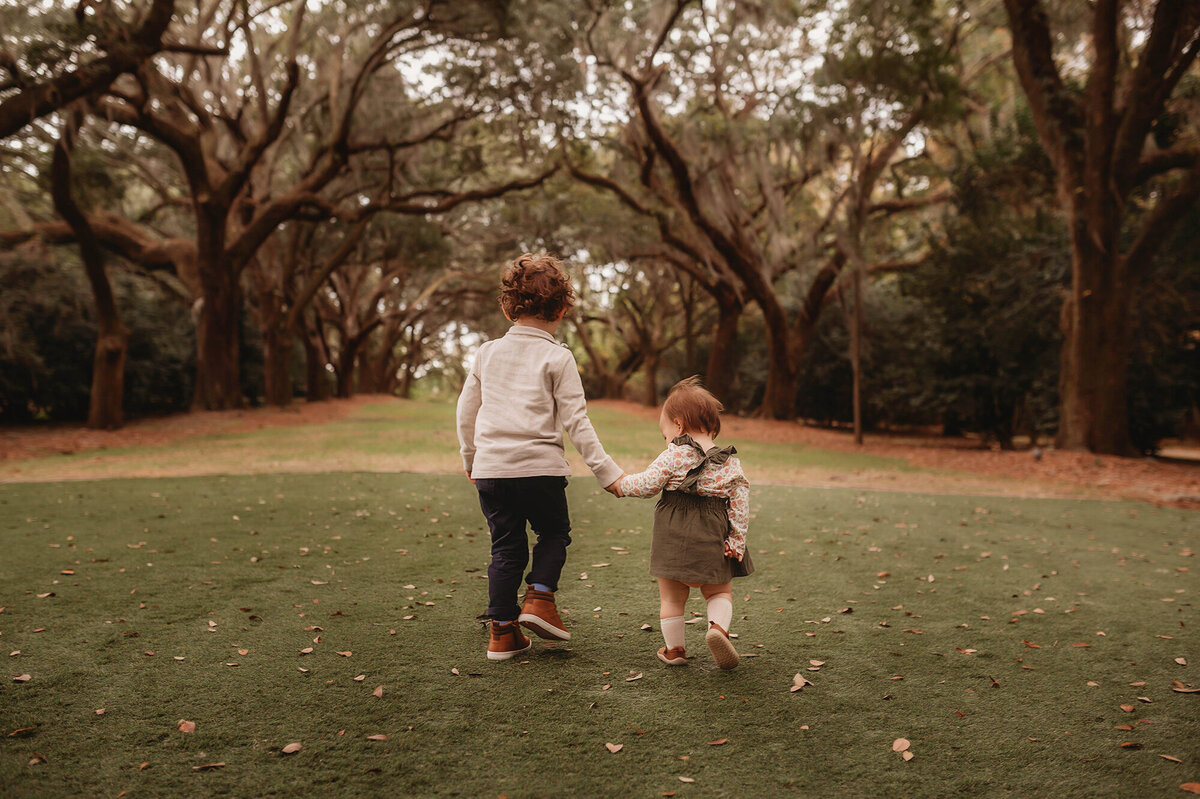 Siblings walk along together during Family Photos in Charleston.
