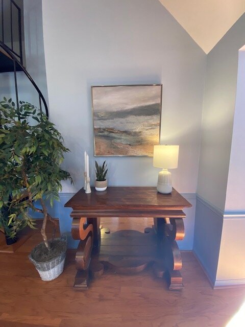 entry table with art and lamp