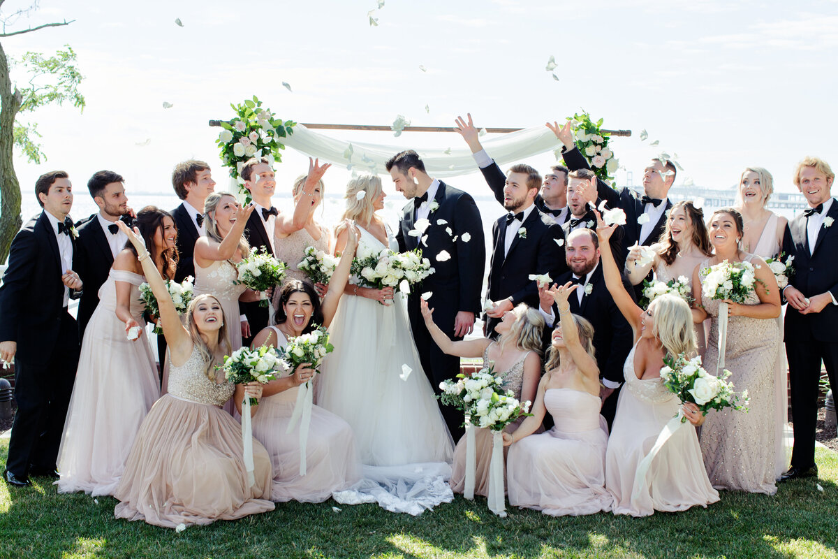 Bridal party throwing flowers with their bride + groom