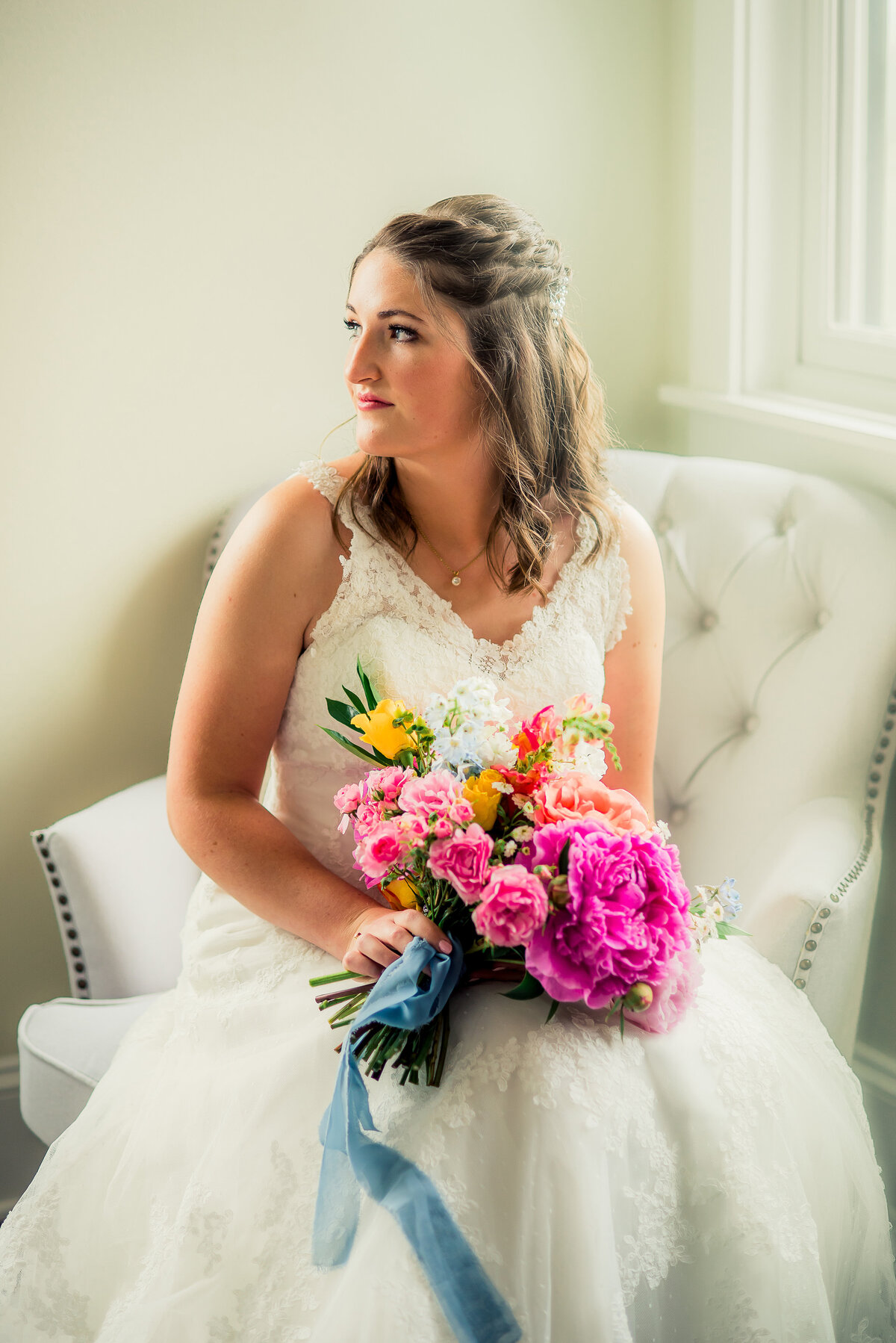 bride resting on chair with bouquet