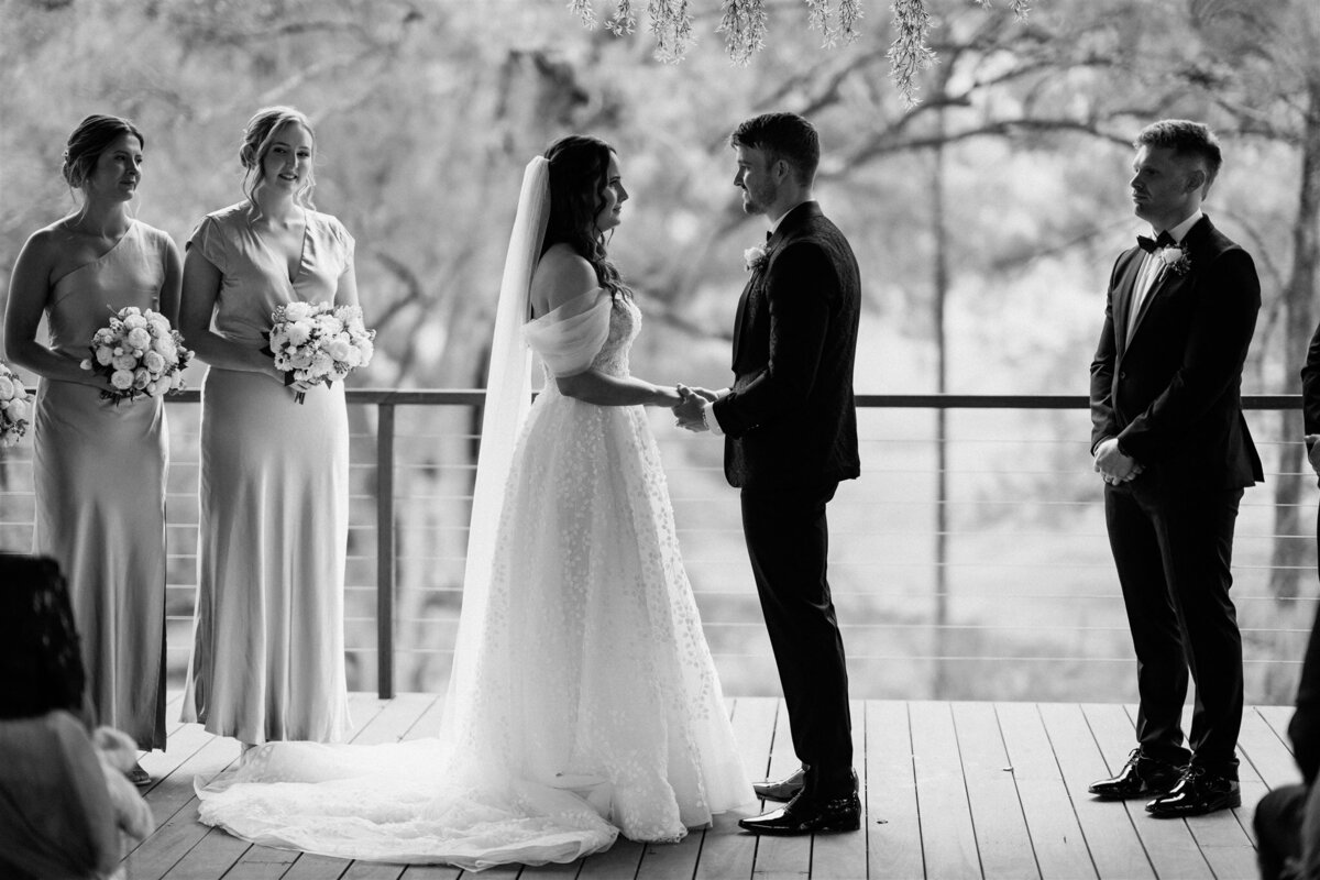 A couple stands lovingly at their ceremony, exchanging vows with heartfelt emotion.