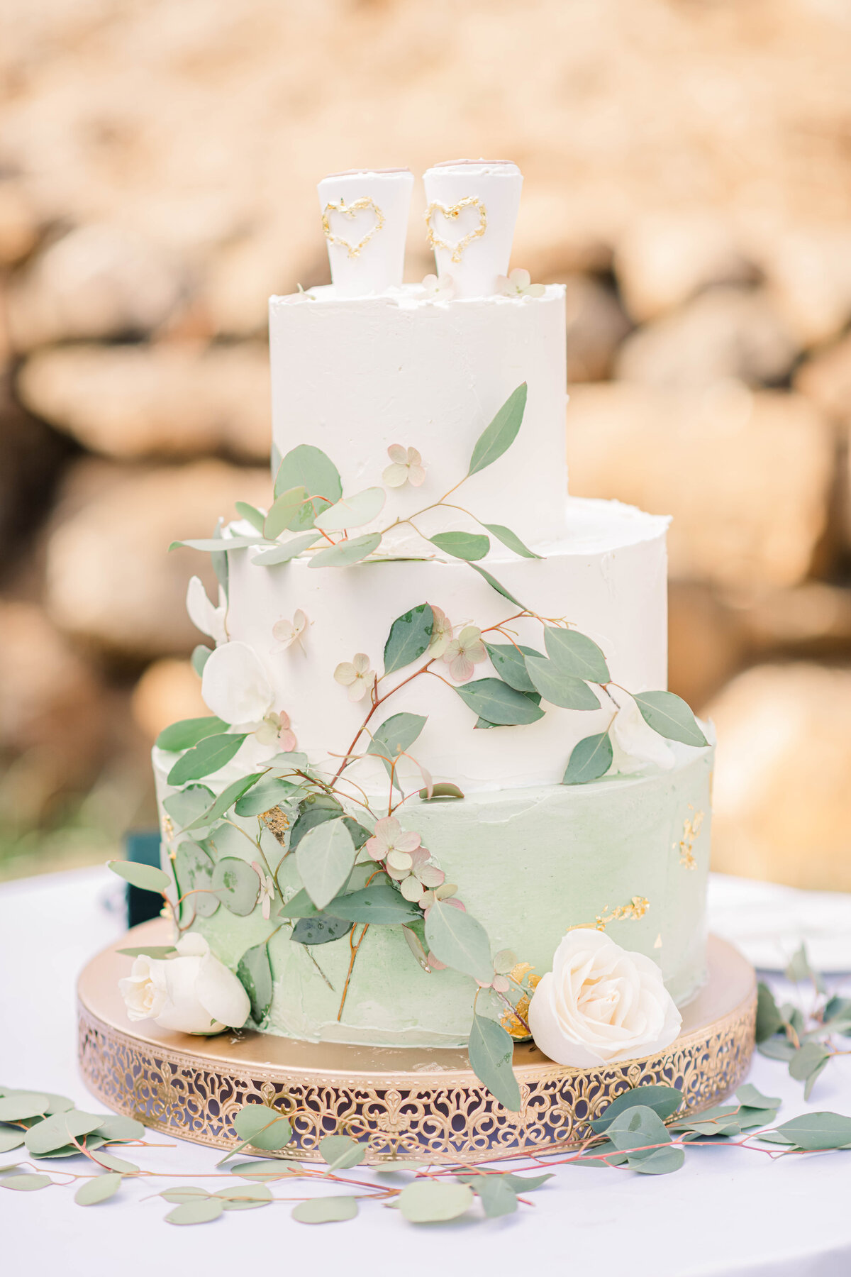 wedding cake covered in eucalyptus