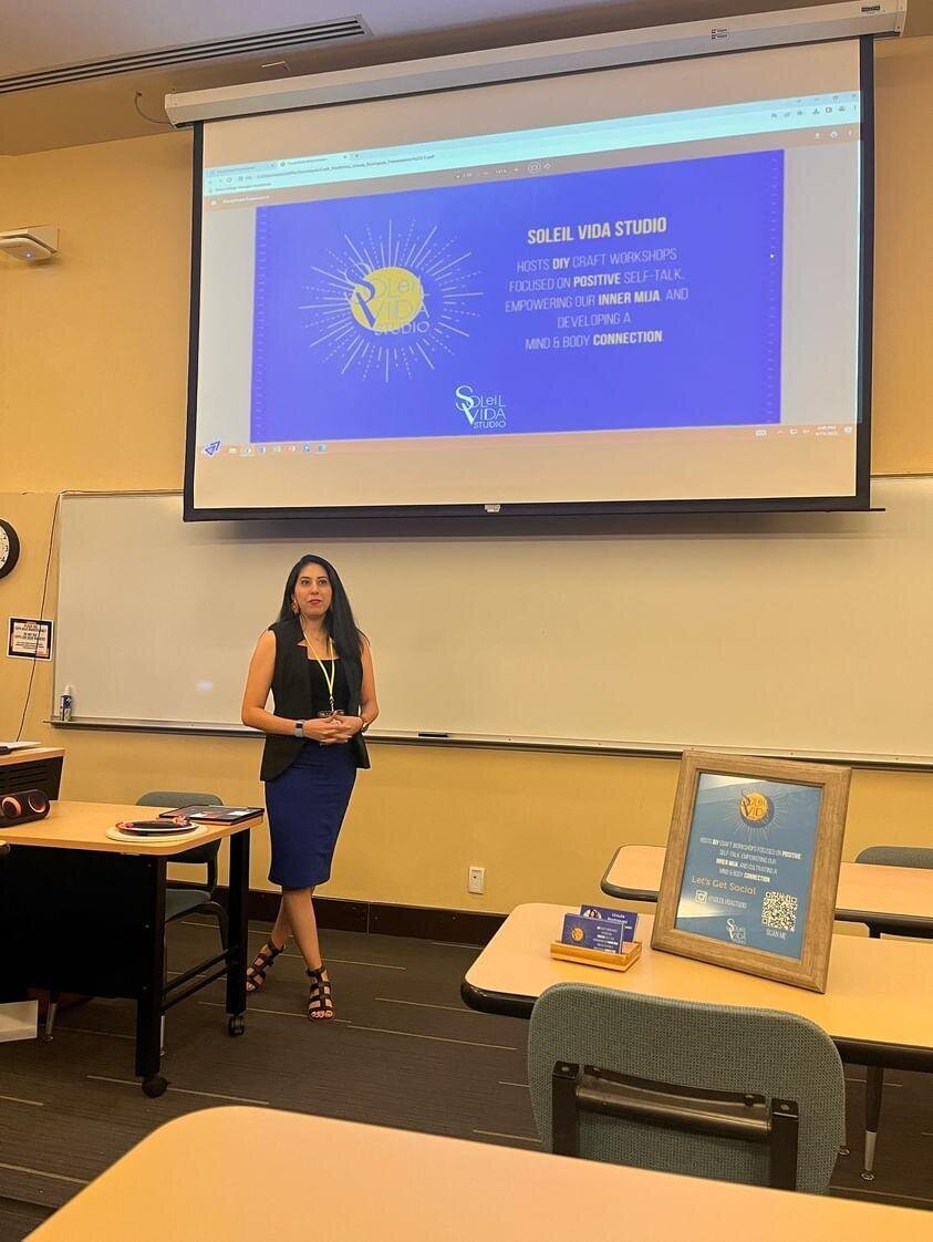 The style as the founder, adorned in a black dress, unveils her artistic vision. In a conference room, she presents a captivating presentation adorned with the yellow submark logo.