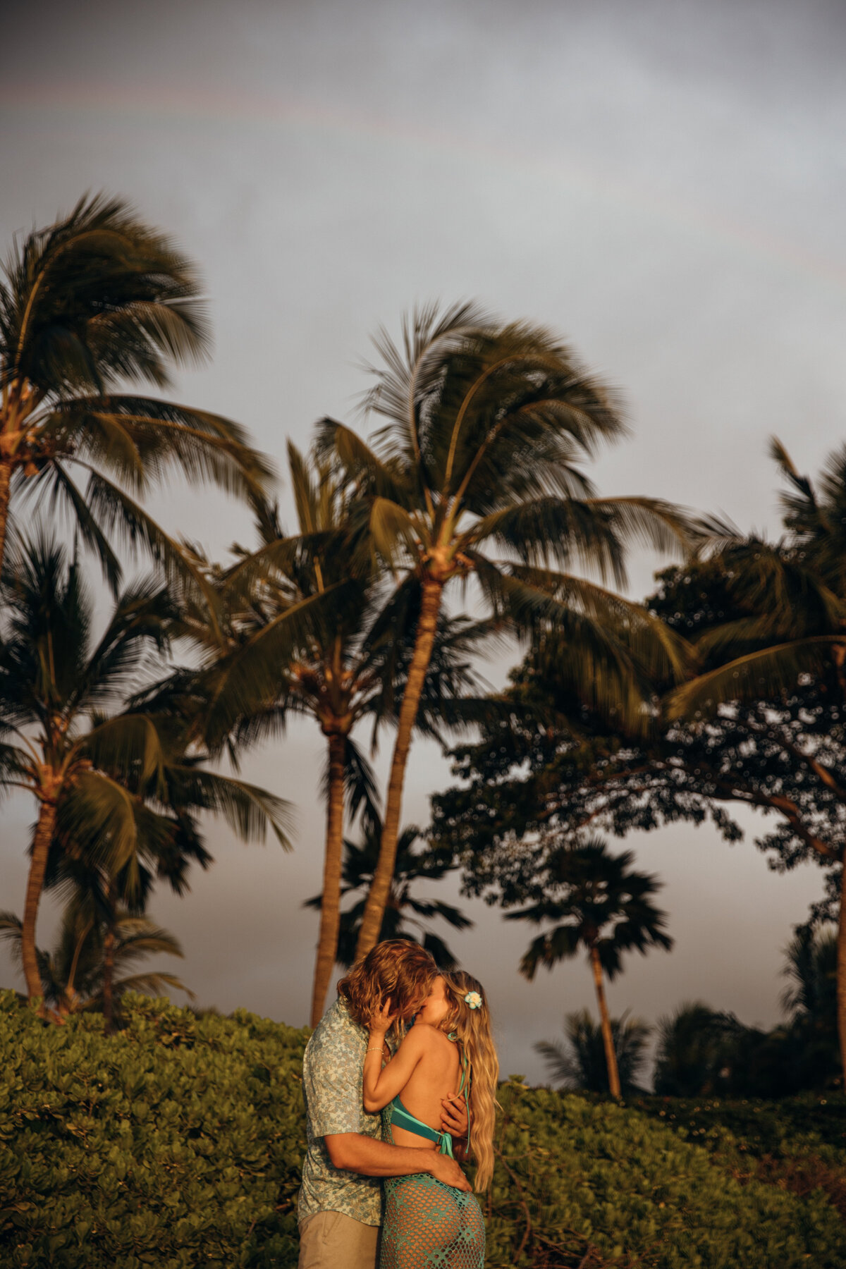 Hawaii Engagement Photographer captures couple kissing while palm trees sway