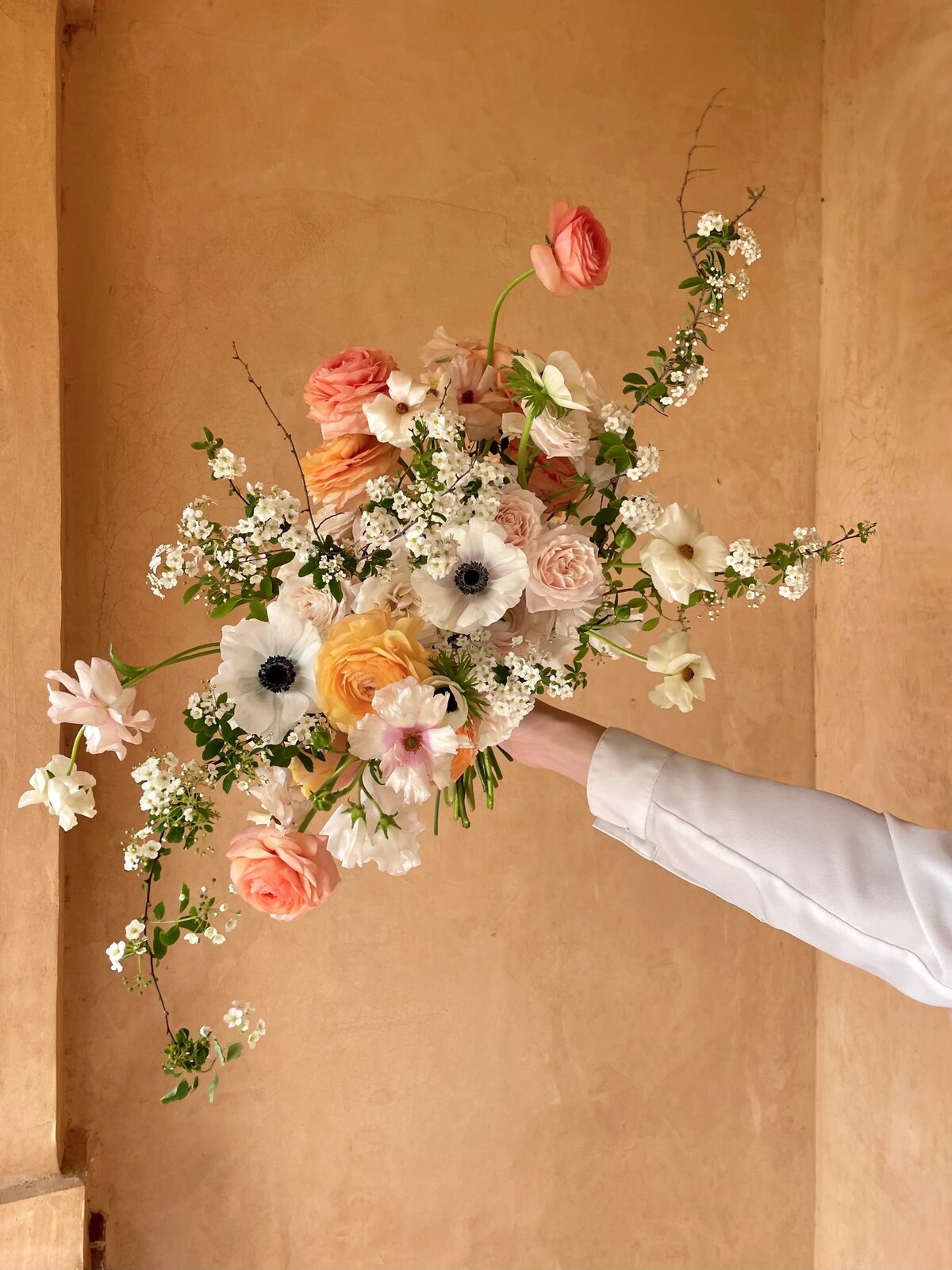 peach and white bridal bouquet spring flowers ranunculus anemone spiraea