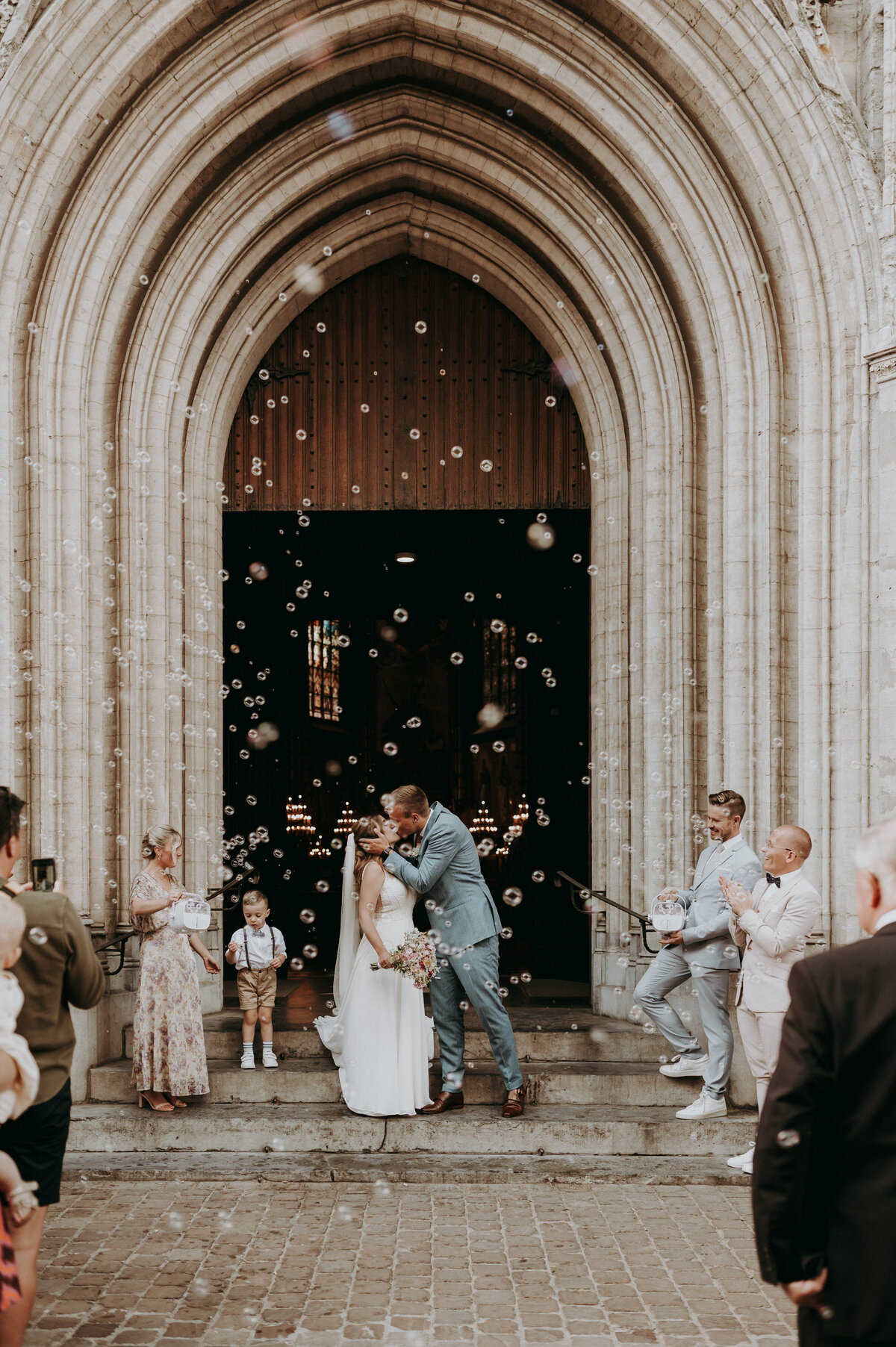 Bruidspaar wandelt uit kerk en kust elkaar.