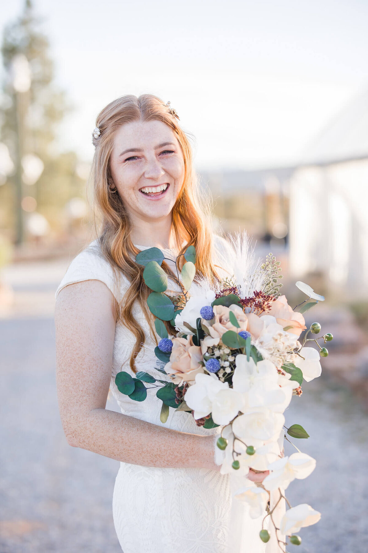 Beautiful red headed bride happily laughing with her bouquet, captured by las Vegas Wedding photography expert, Jessica Bowles