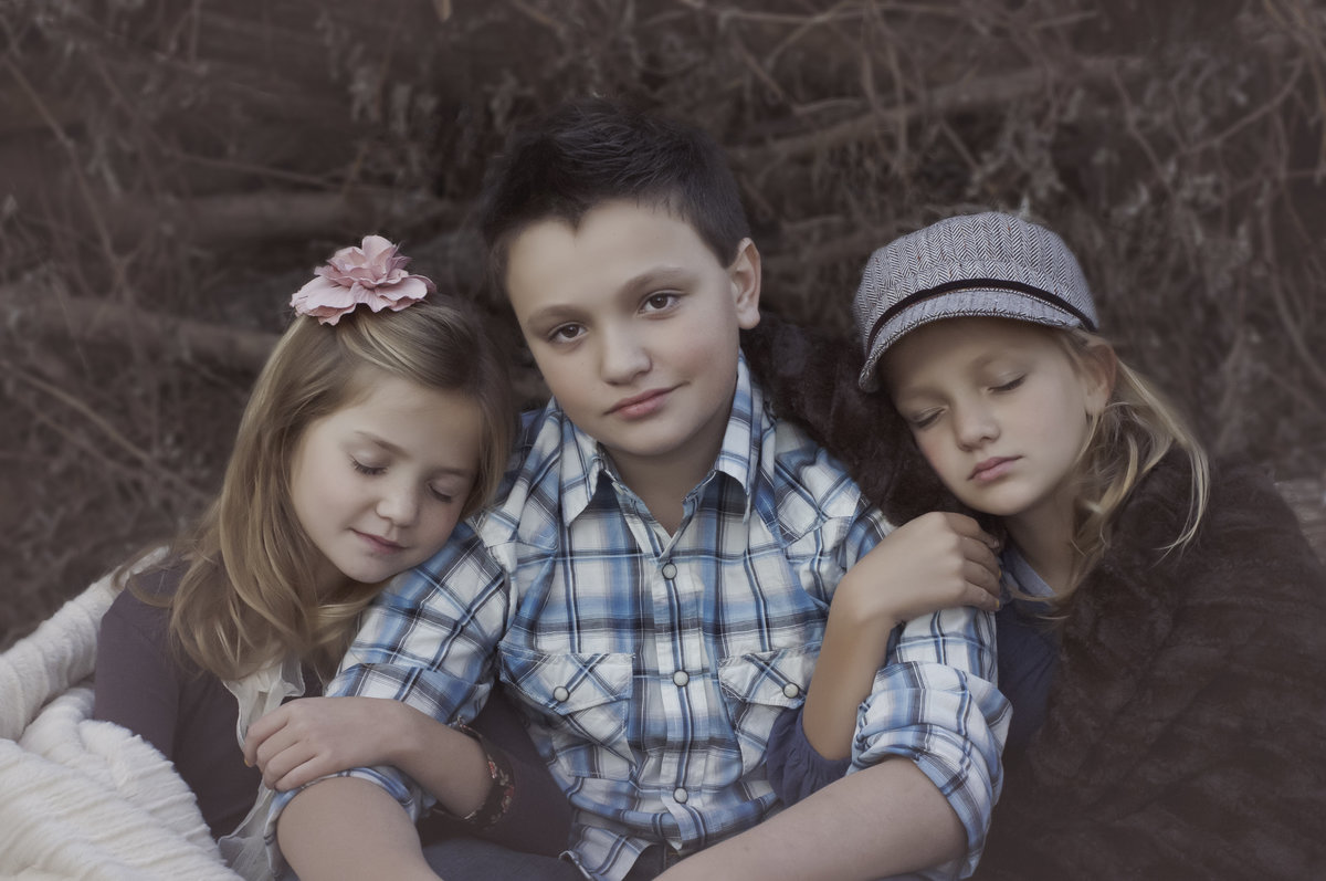 Heartwarming portrait of two sisters hugging their brother in Gilliam, LA by Sarah Farmer, capturing sibling love.