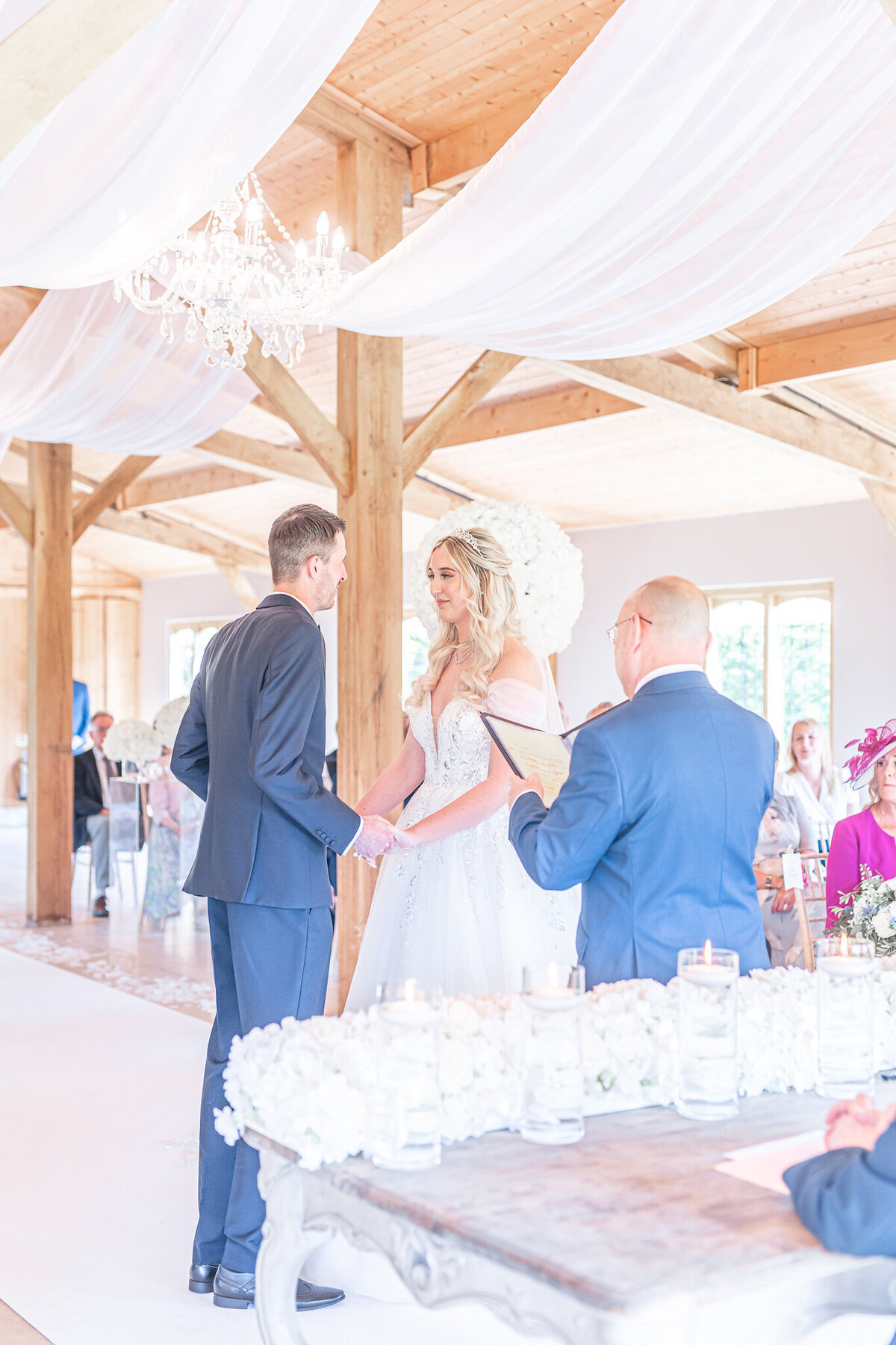 Bride and groom holding hands facing each other during their ceremony at Merrydale Manor Cheshire