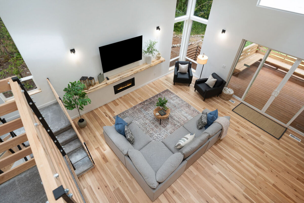 Overhead view of a cozy living room with a large sectional and tall windows