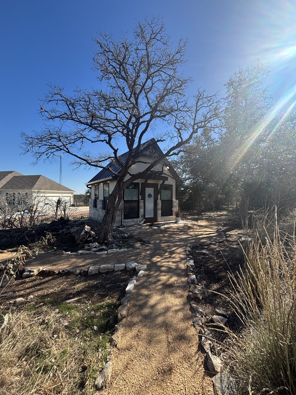 Hill country backyard ADU with limestone facade and stucco siding. Built by Elbow Room in Fair Field, TX.