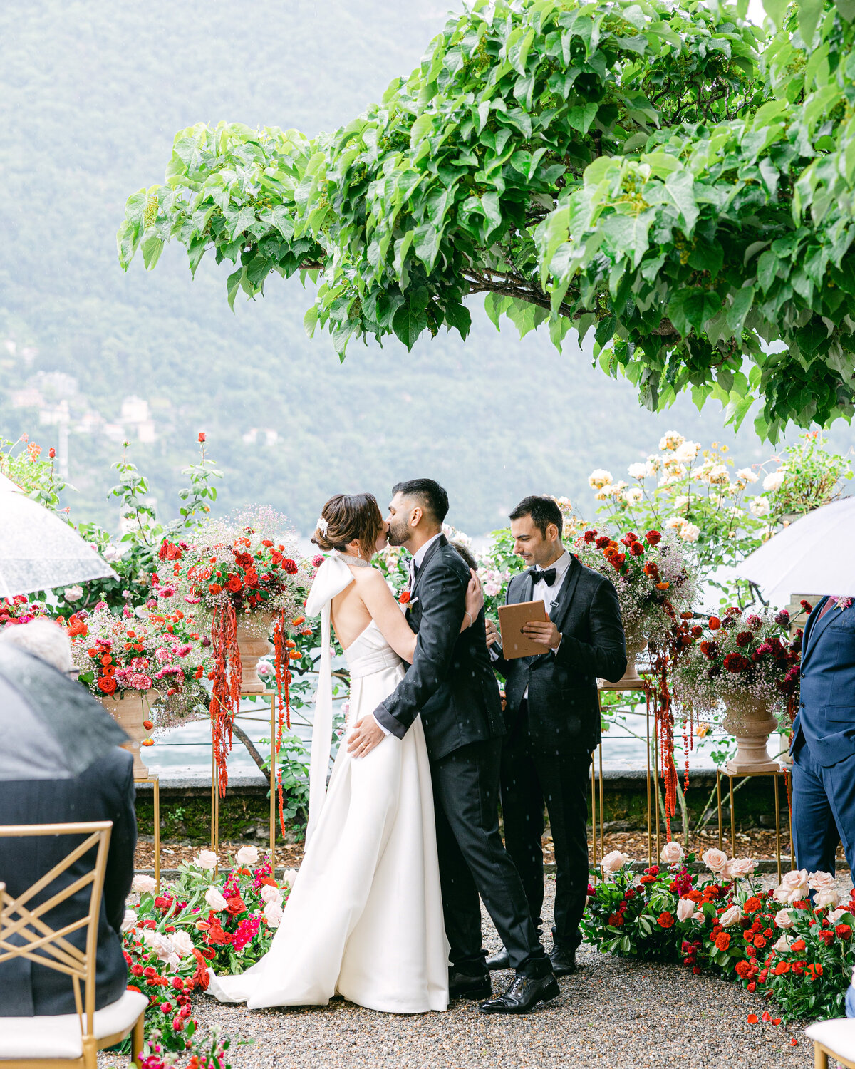 Bride and groom's first kiss with bright flowers at destination wedding on Lake Como