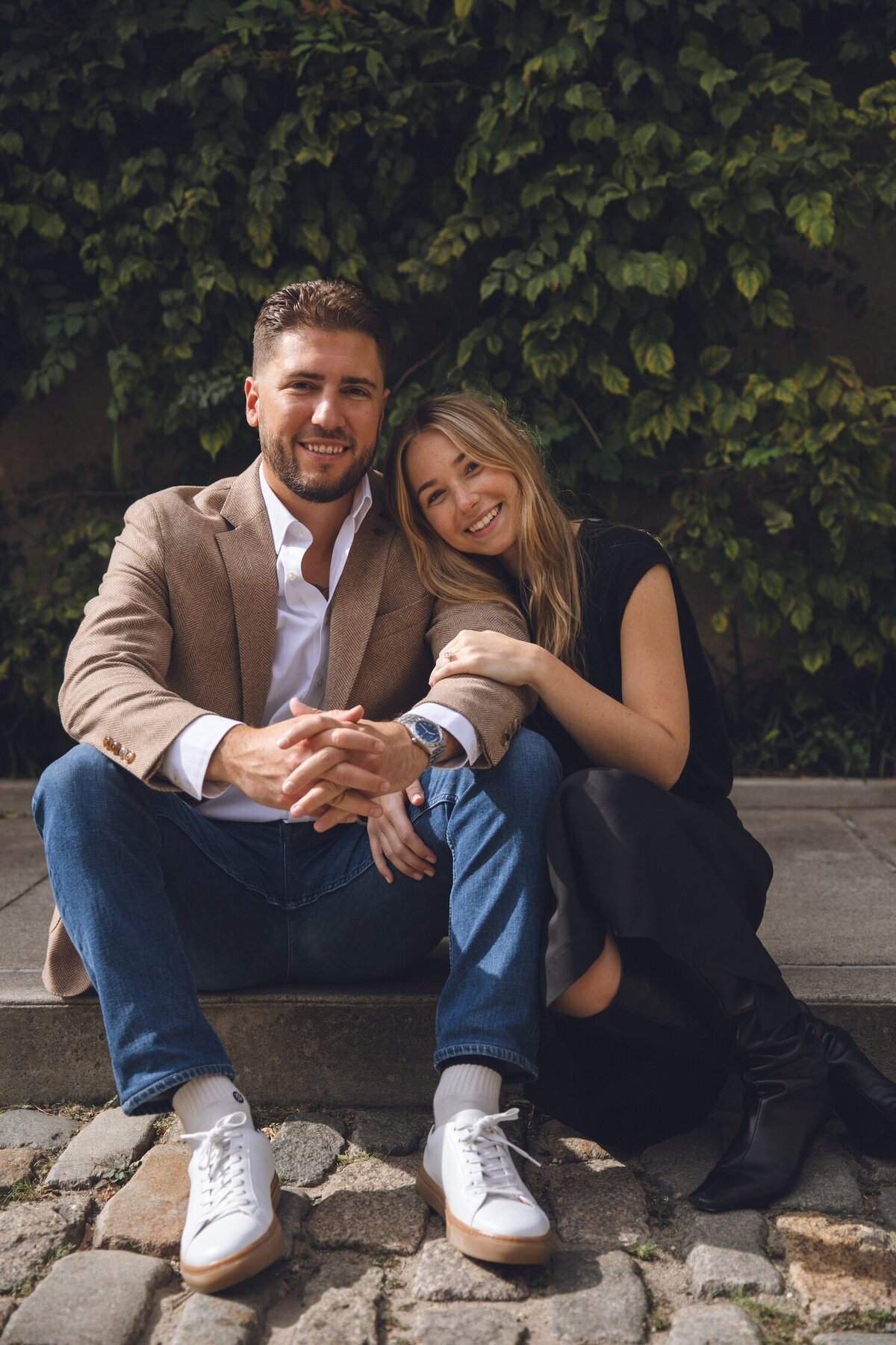 Couple sitting on steps, sharing a quiet, joyful moment together.