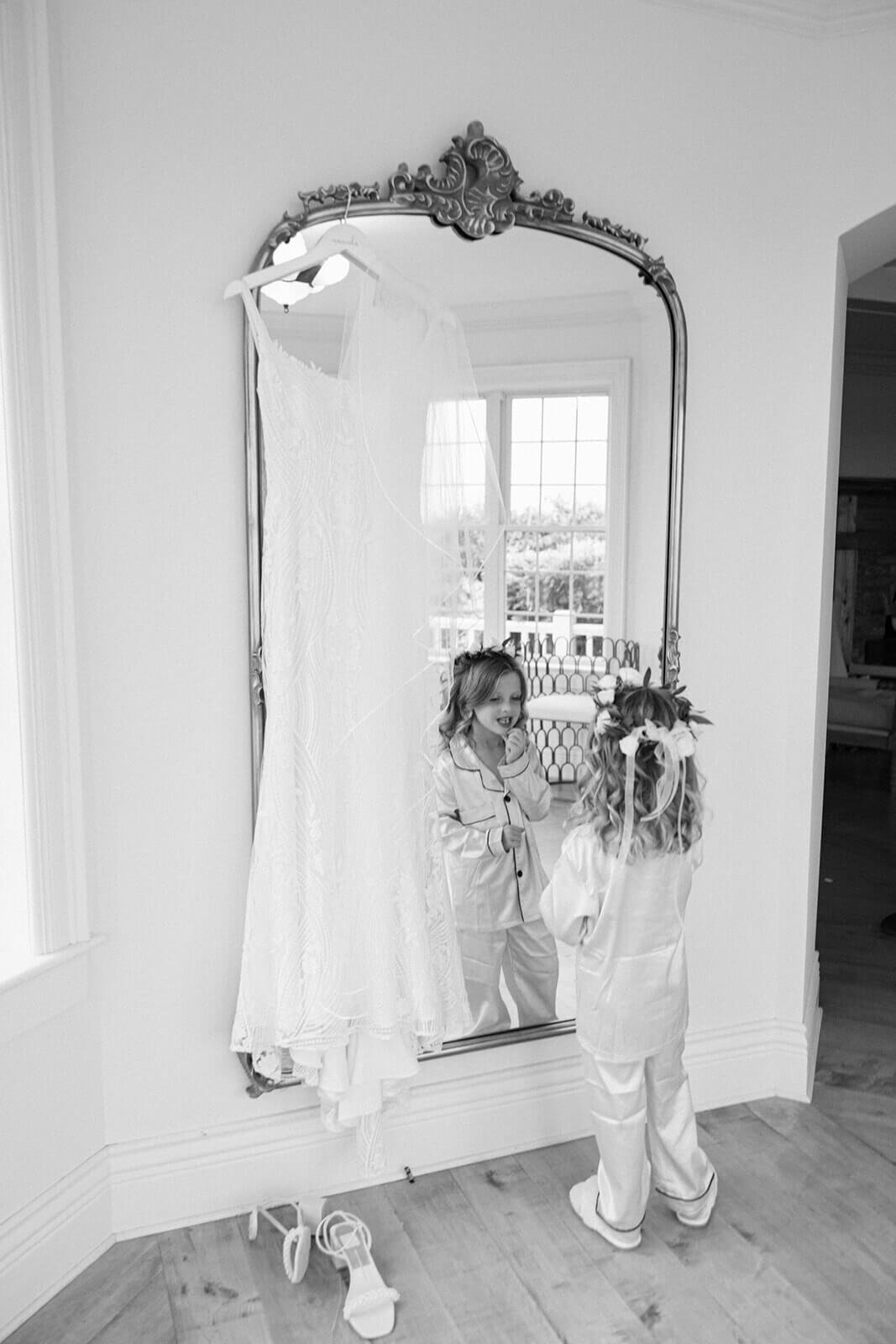 Little girl looking in mirror before wedding at Finger Lakes New York