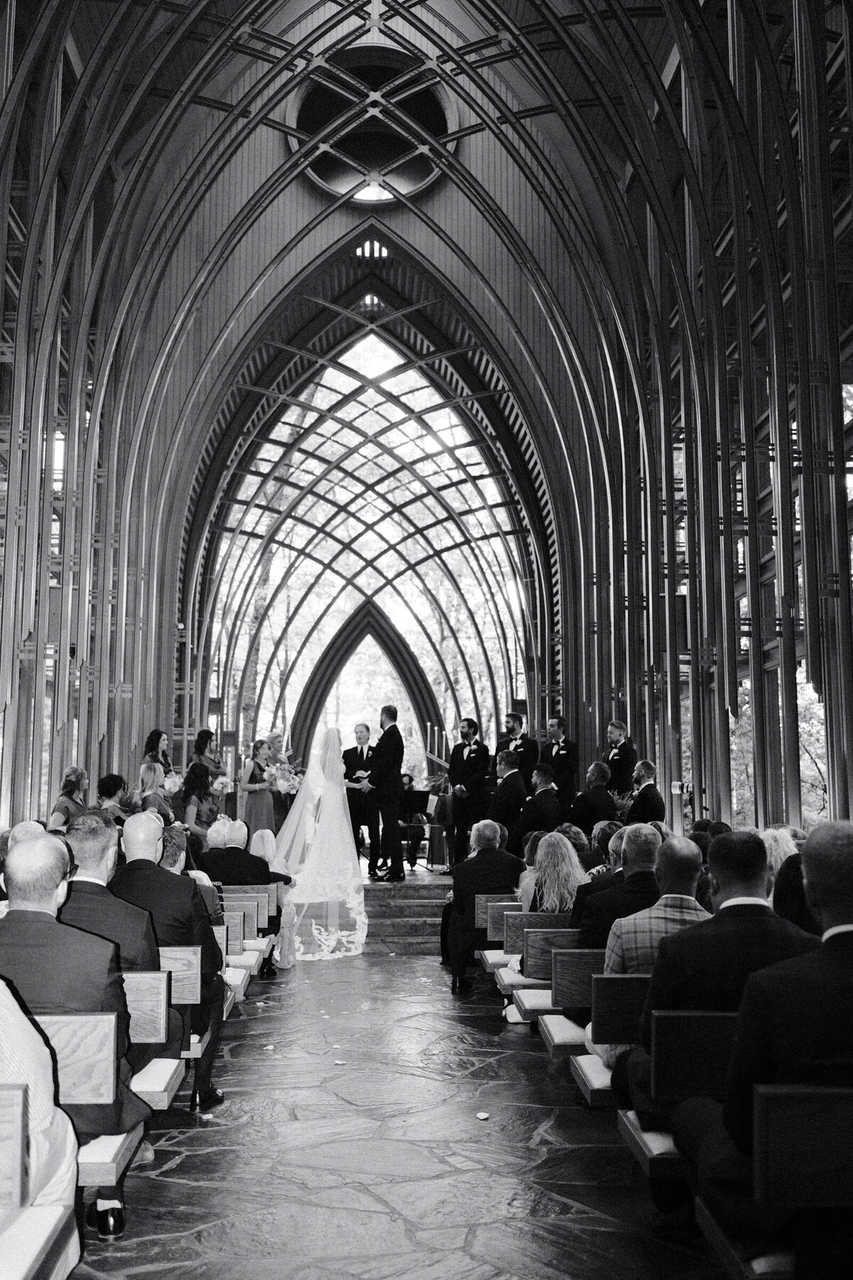 A black and white wedding photo of the bride and groom on the alter at Anthony's Chapel in Hot Springs Arkansas