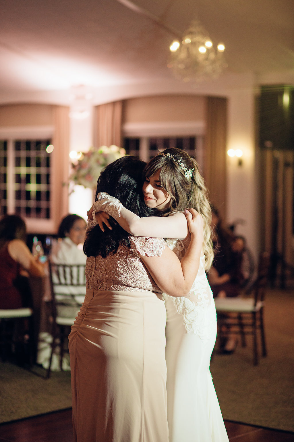 Wedding Photograph Of Bride Smiling While Hugging A Woman In Light Brown Dress Los Angeles