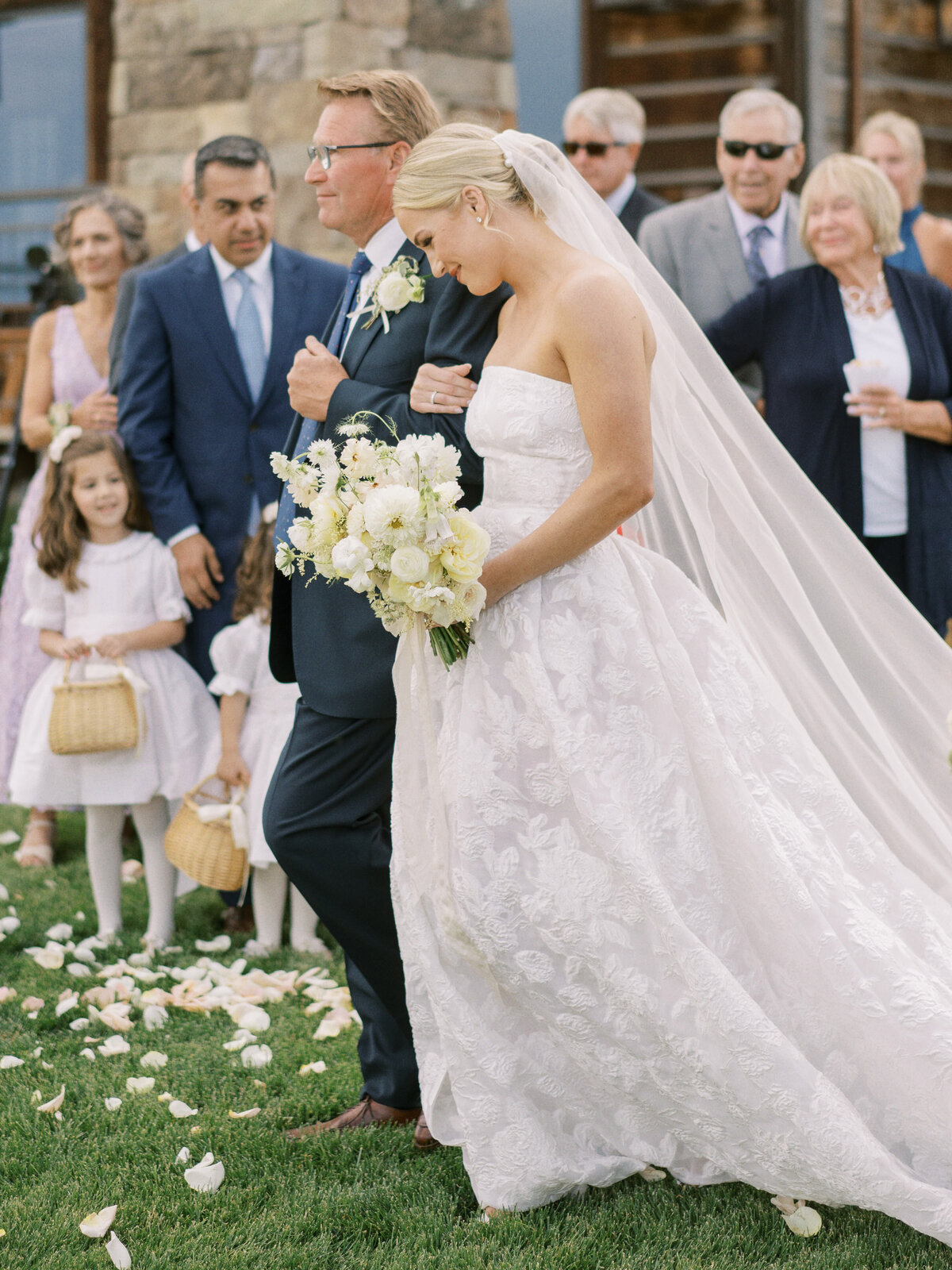 a bride being walked down the aisle by a man
