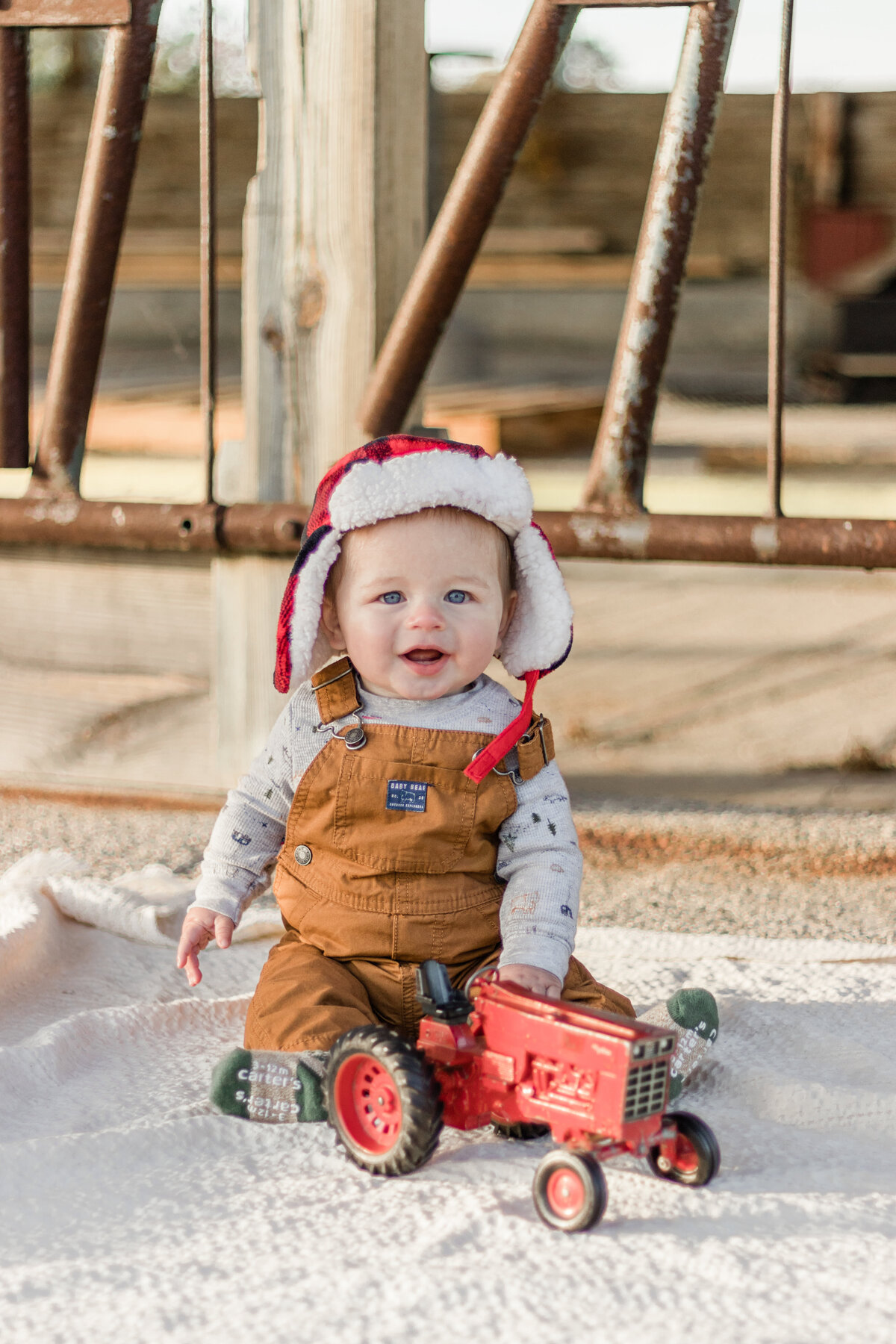 baby sitting with a toy tractor