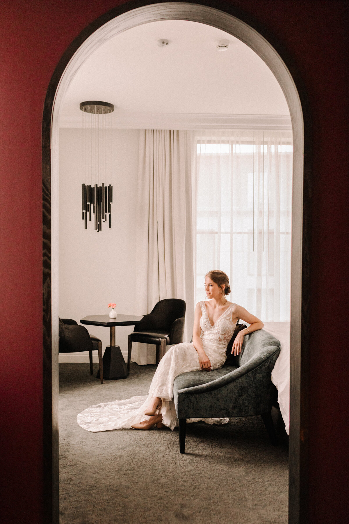 bride sitting next to a bed in a hotel room