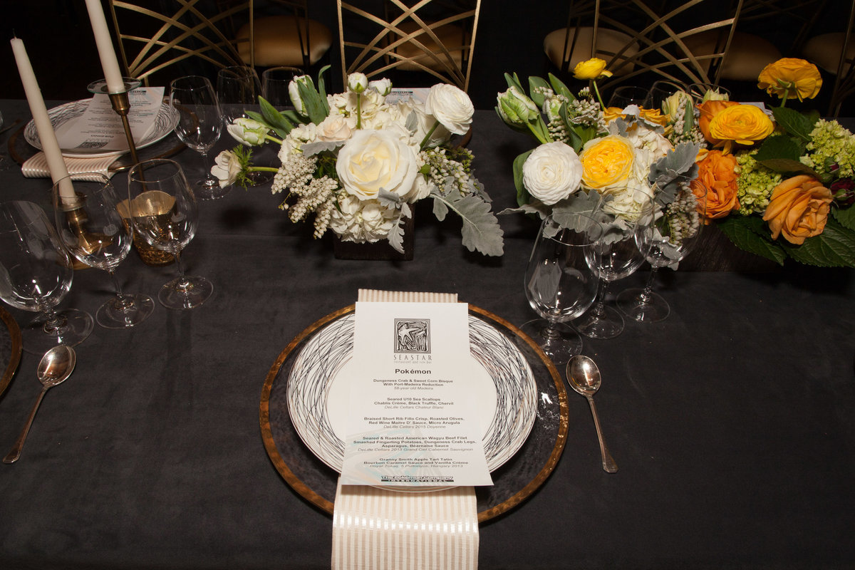 place setting with glass charger plate and centerpieces in yellow, white, green