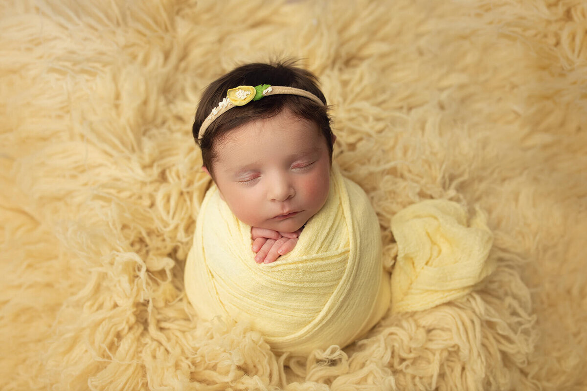 beautiful baby girl asleep sitting up in yellow