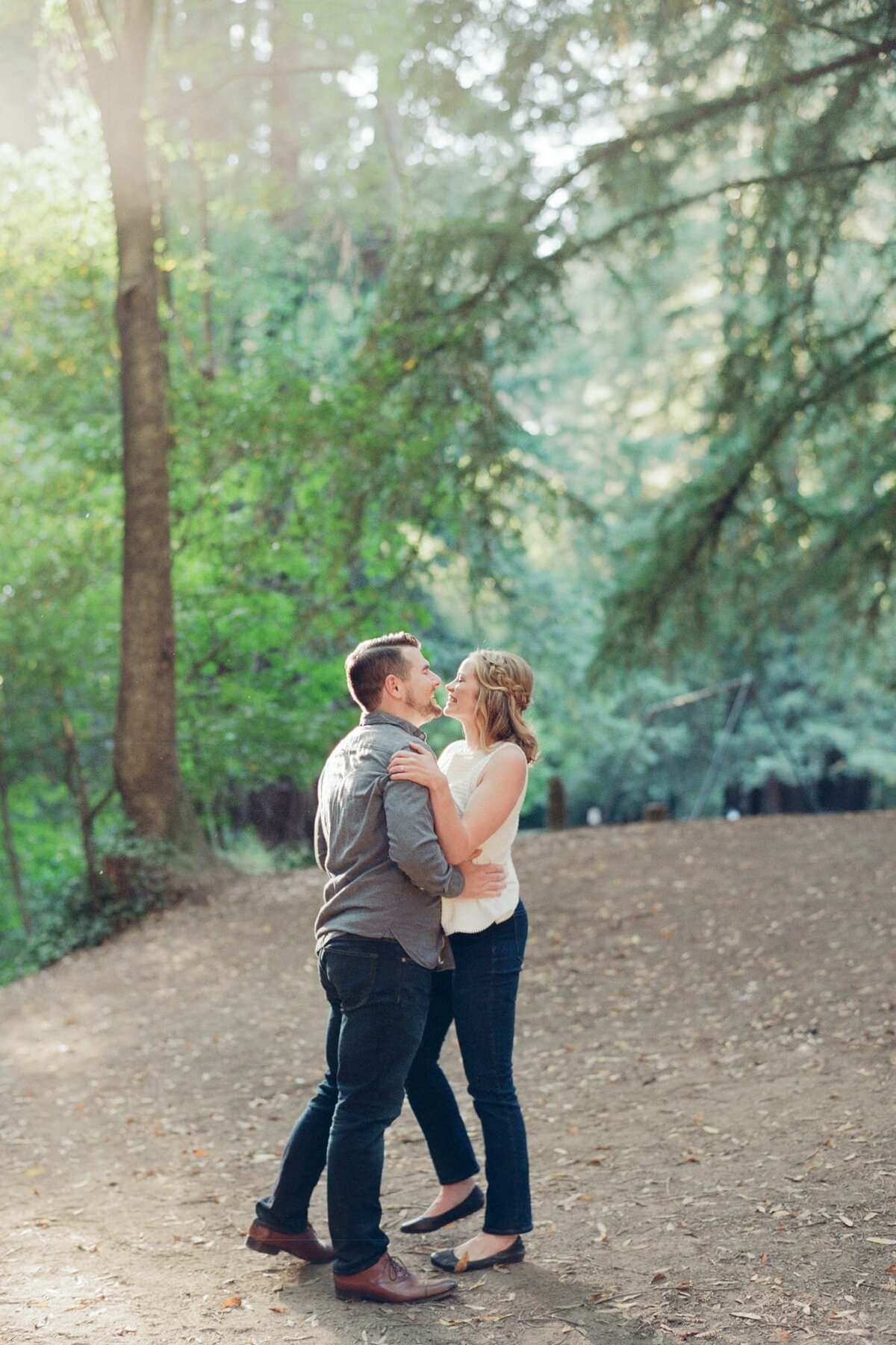 Engaged couple hug each other and pose for editorial style mountain top engagement photography.