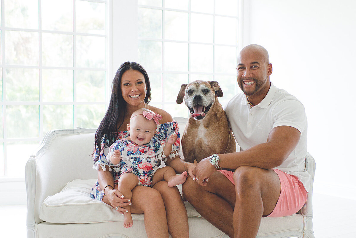 family celebrating first birthday with dog in photography studio