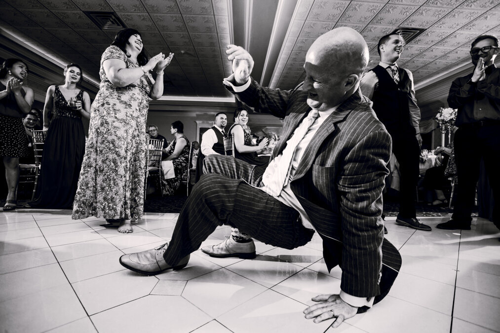 A man in a suit is dancing on the floor.