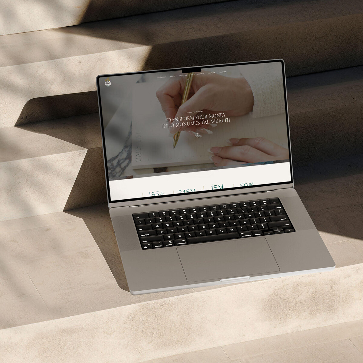 Laptop displaying the TMW Advisory homepage, positioned on modern stone steps with natural lighting—showcasing clean, strategic website design

