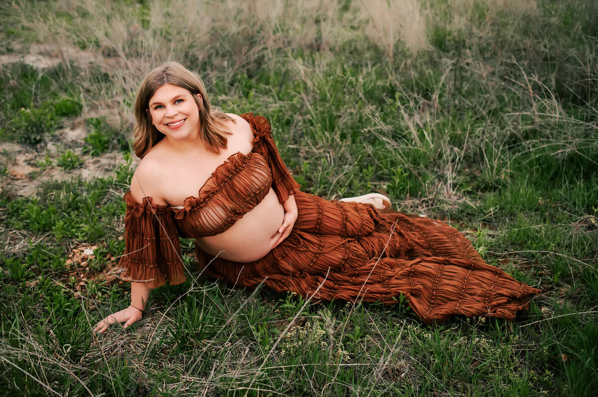 Joplin MO maternity photographer Jessica Kennedy of The XO Photography captures pregnant mom sitting on grass in a brown dress