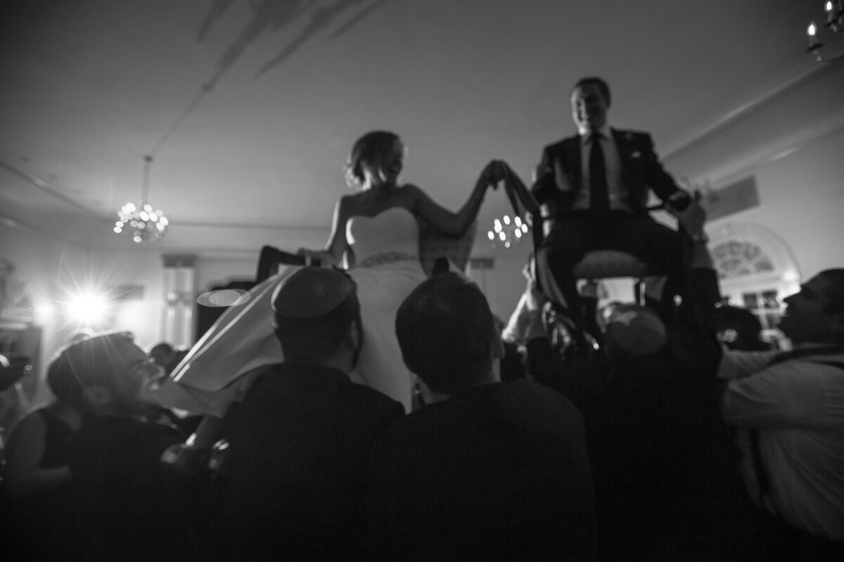 Bride and Groom lifted on chairs during hora of their Boston wedding reception.